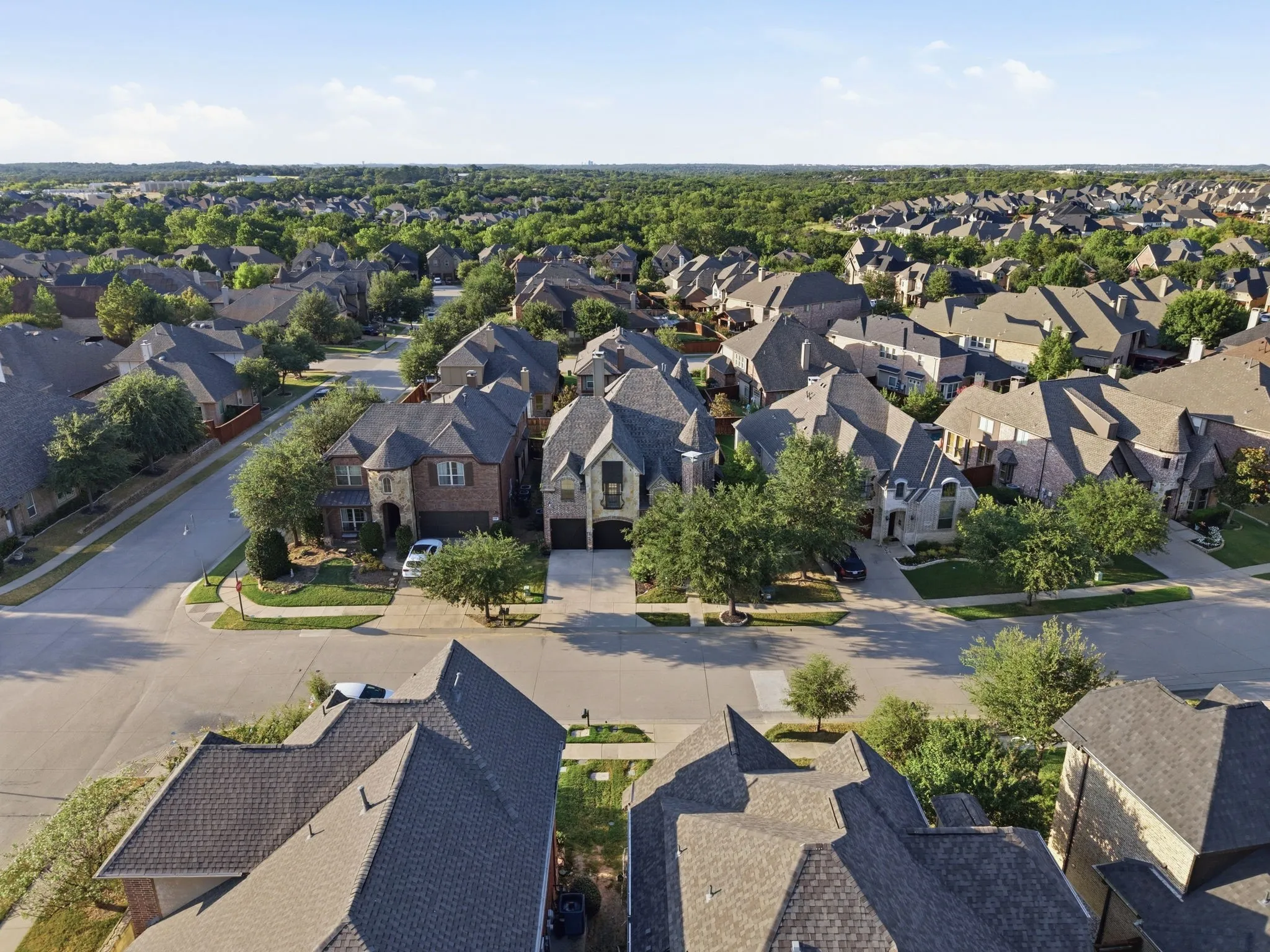 Residential neighborhood featuring mature trees, paved streets, and a variety of architectural styles