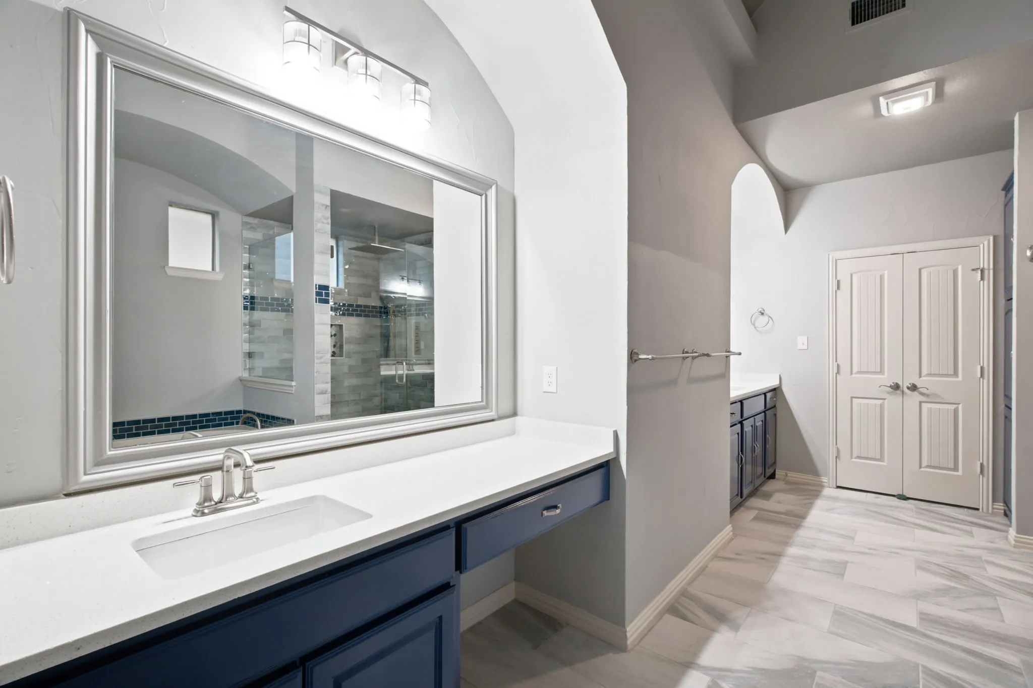 Spacious vanity with a rectangular undermount sink, brushed nickel faucet, and a large framed mirror