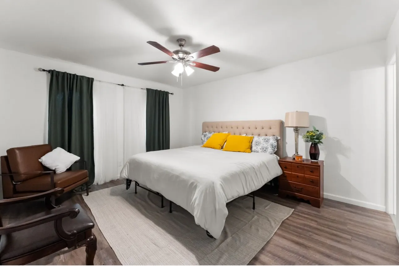 Recessed lighting, wood-finish flooring, ceiling fan with integrated lighting, window with curtain rod, and white walls