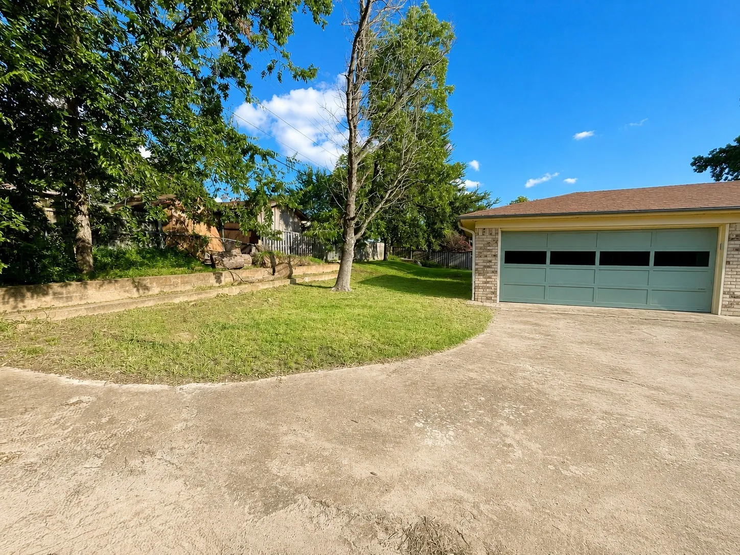 Garage located behind house including beautiful backyard.