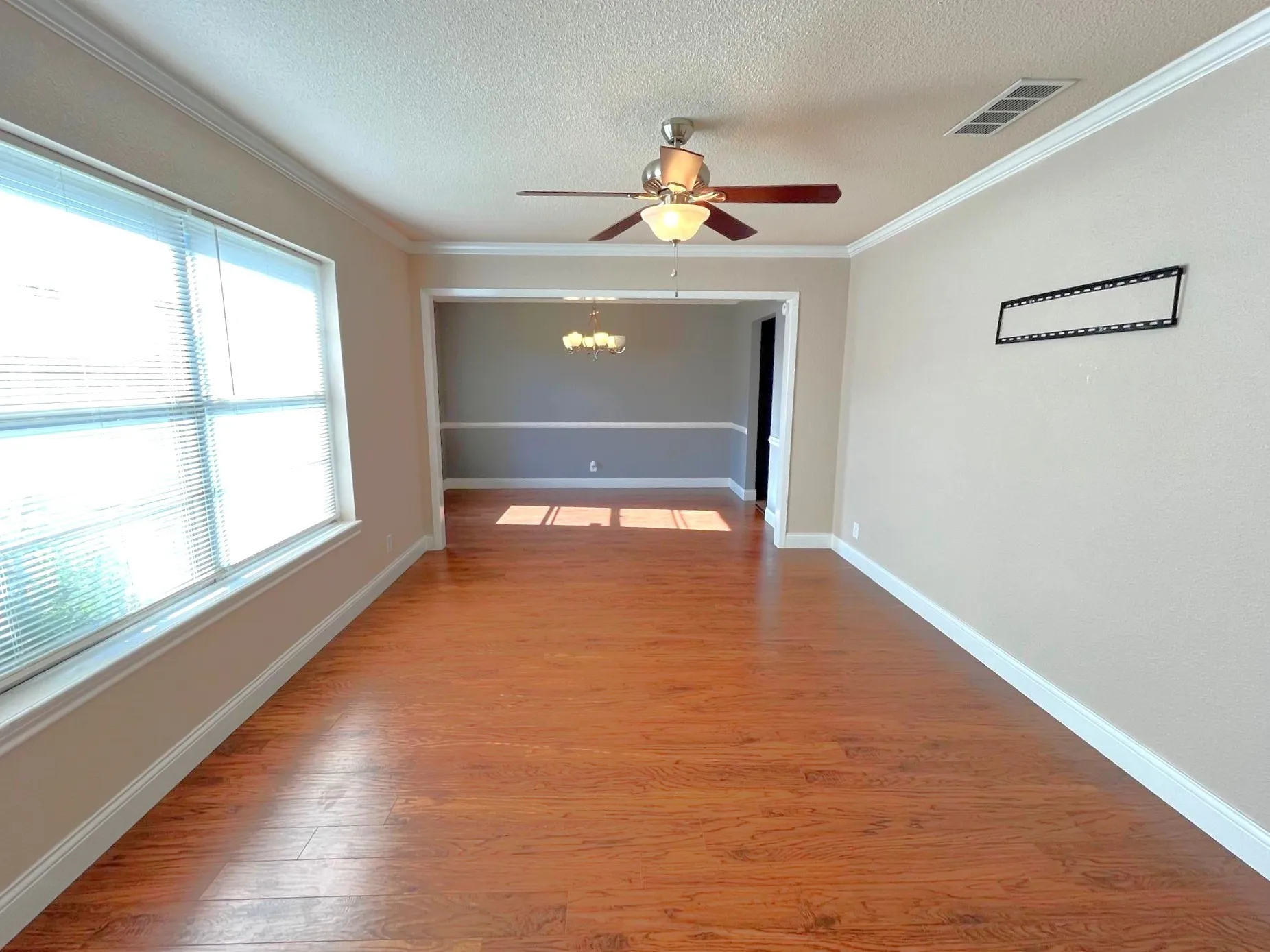 Wood-style flooring , ceiling fan with integrated lighting, window with blinds, and crown molding