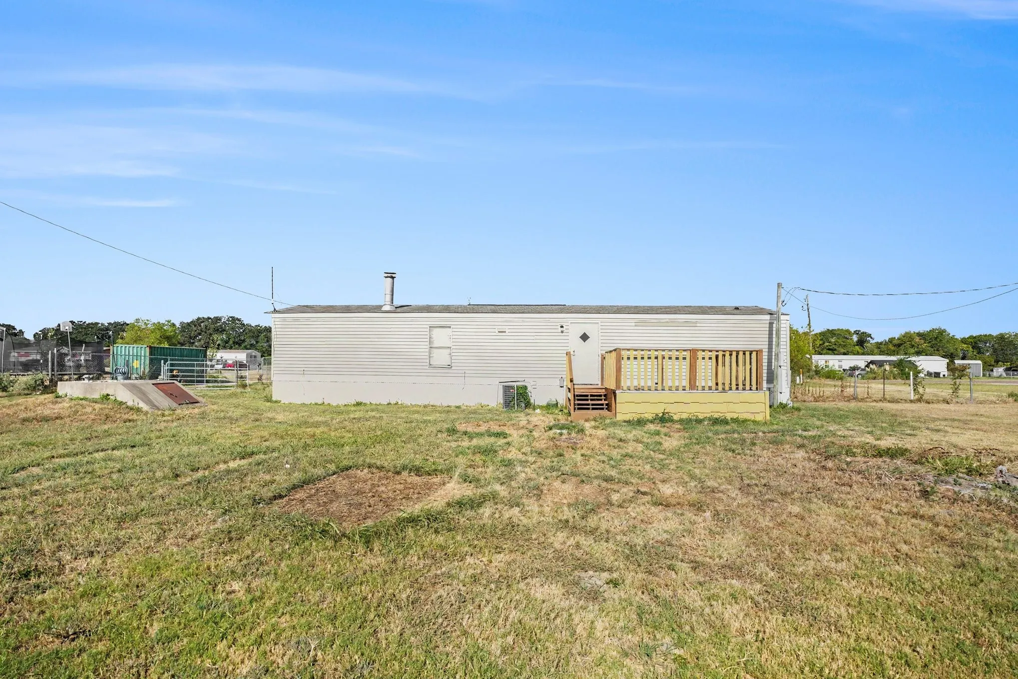 Exterior featuring horizontal siding, a light-colored roof, and an attached wood deck with railings
