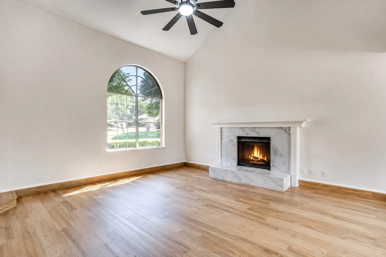 Spacious living room with high ceilings and fireplace.