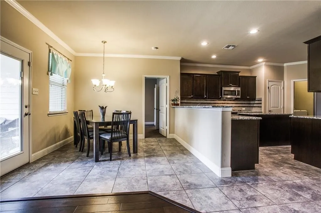 Dining area featuring a chandelier, tile flooring, and a window with blinds