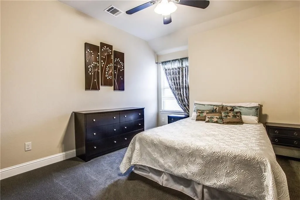 Carpeted flooring, vaulted ceiling, ceiling fan with integrated lighting, window with blinds, and white trim