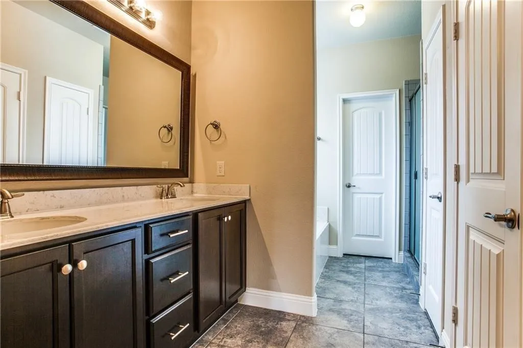 Dual vanity with dark wood-finish cabinetry, light-toned countertop, and undermount sinks