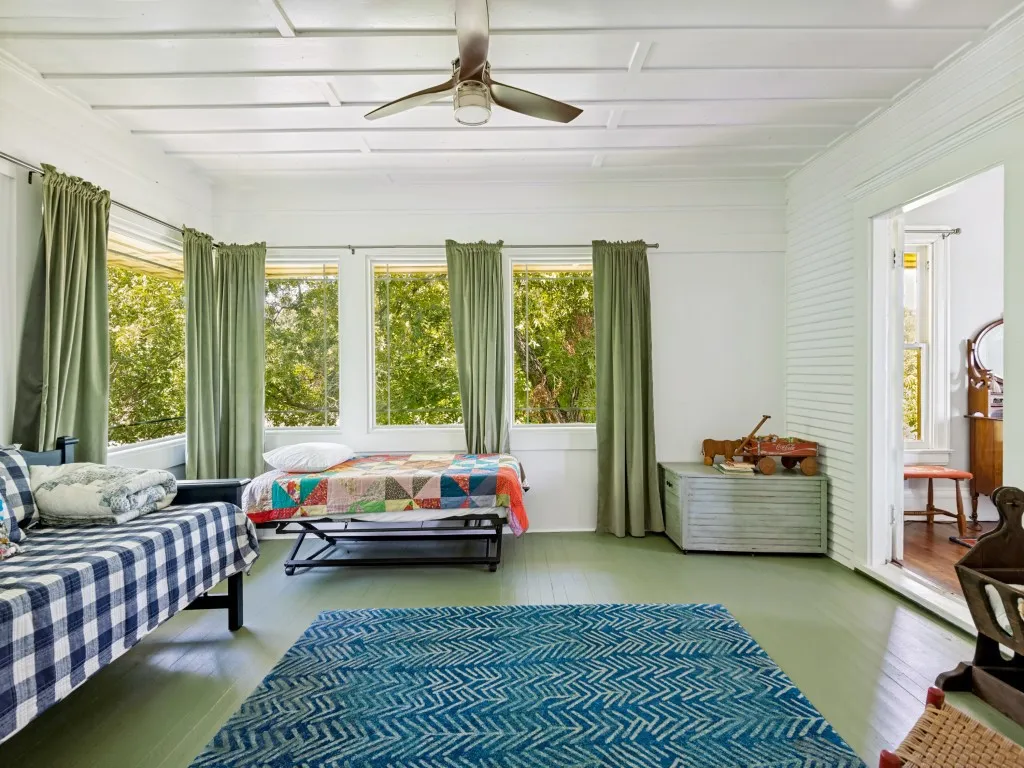 Room featuring painted wood-finish flooring, white walls, and multiple large windows