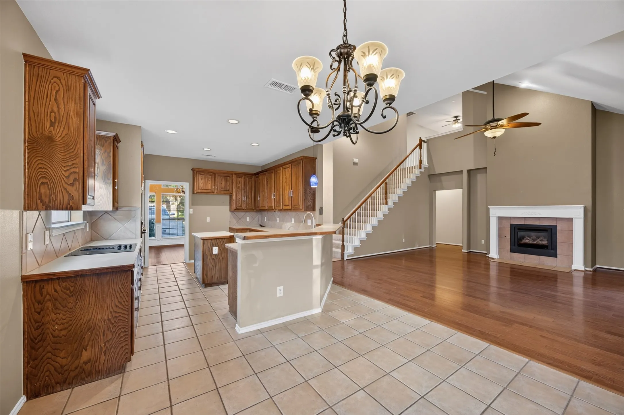 Kitchen with wood cabinetry, tile flooring, and a breakfast bar