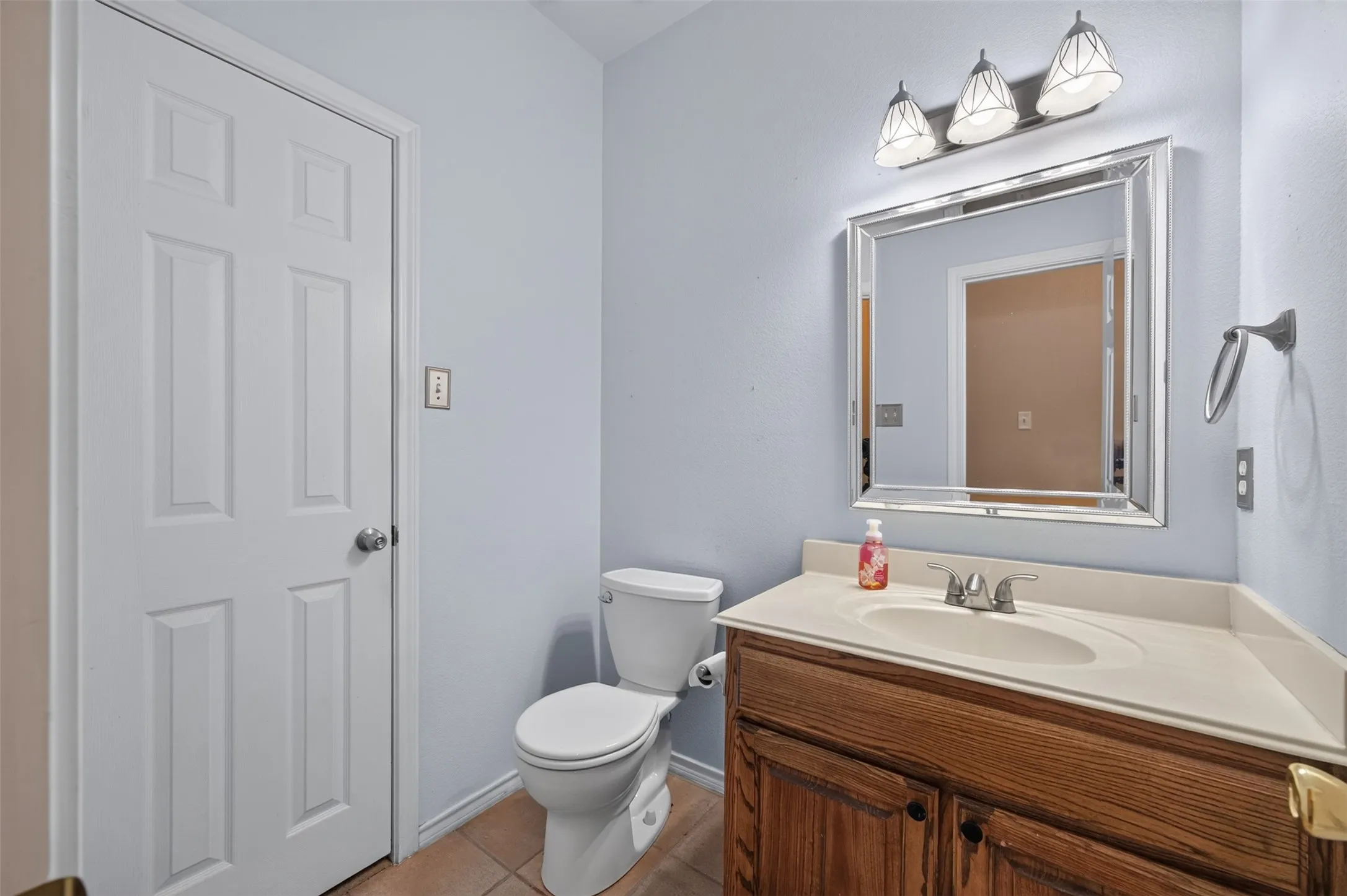 Vanity with an integrated sink, wood-finish cabinetry, and a chrome faucet