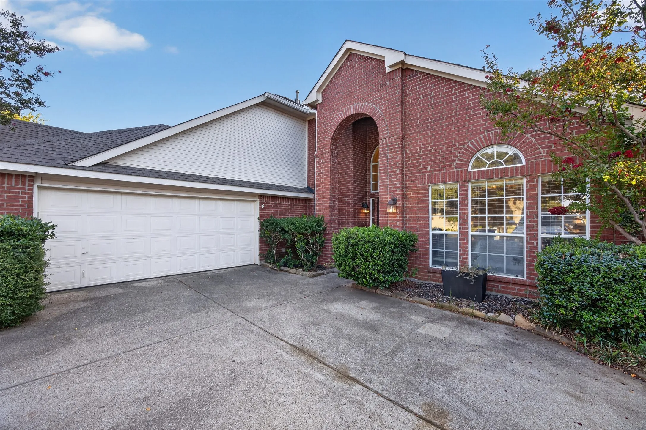 Brick exterior with arched entry, an arched transom window, and a two-car garage