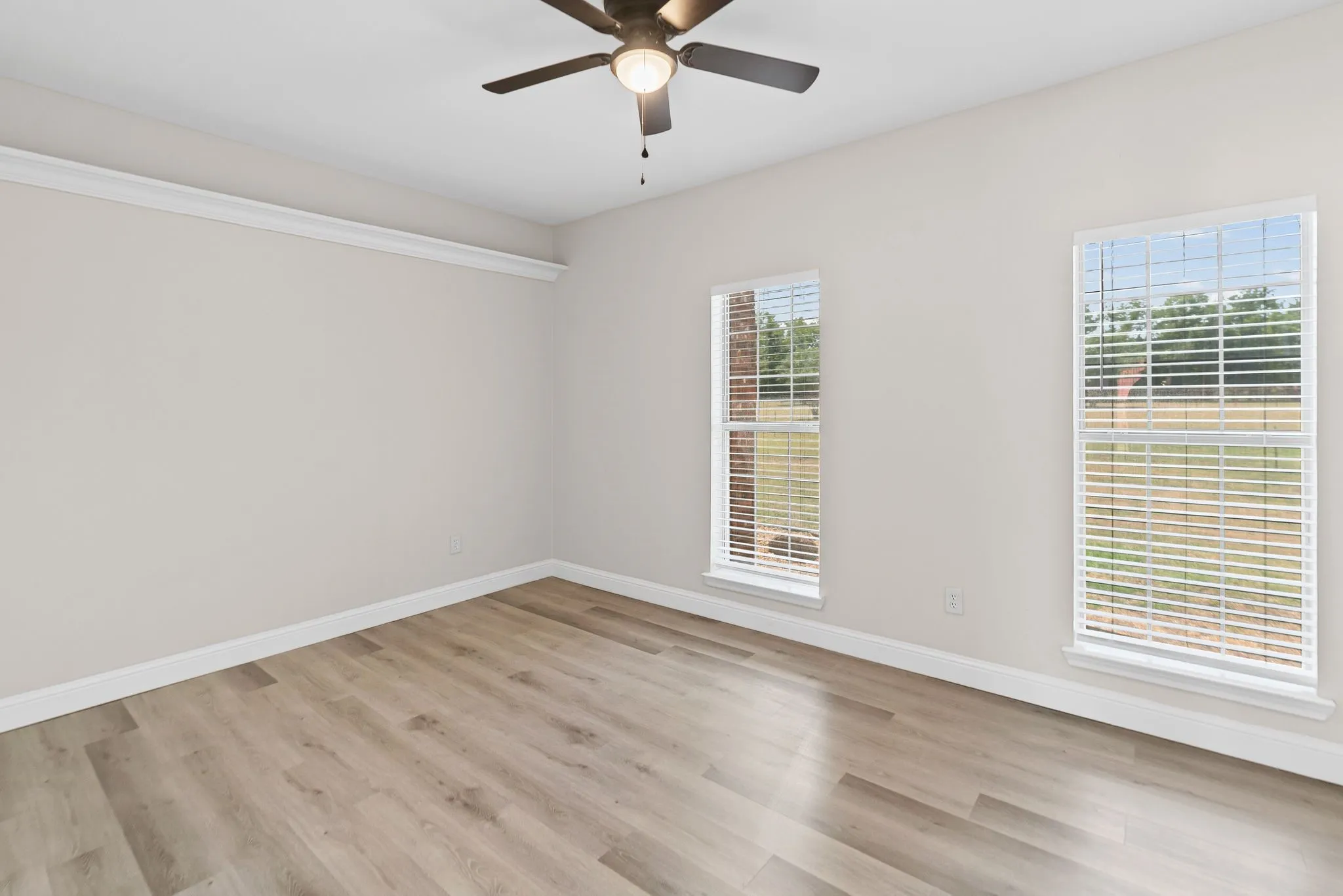 Secondary bedroom Wood-finish flooring with white trim