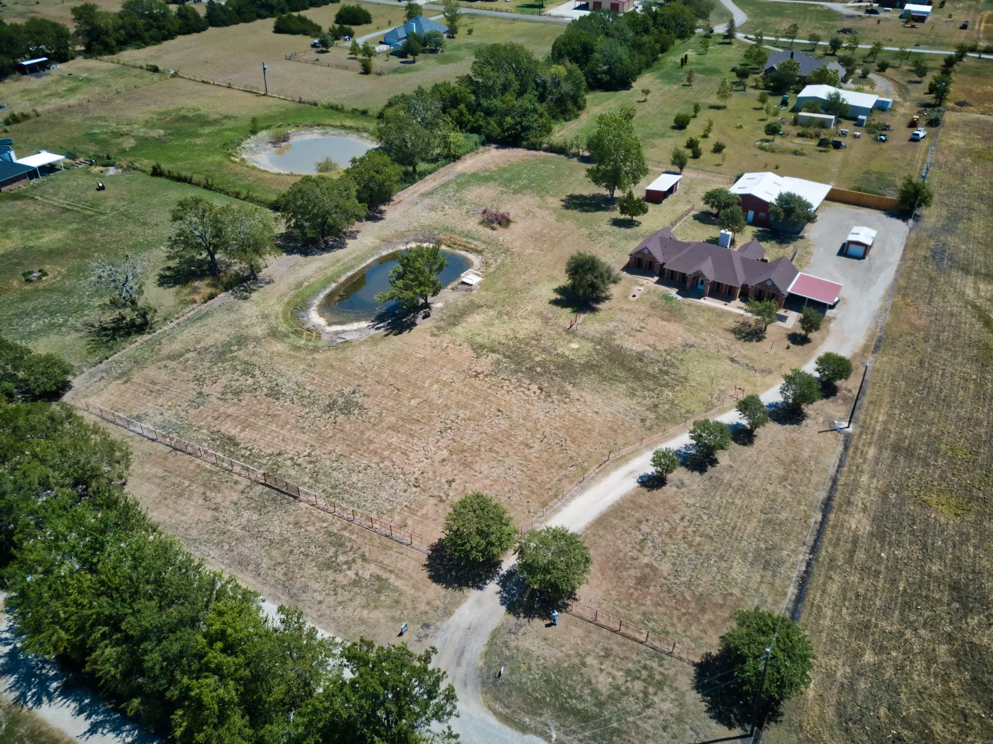 Expansive property featuring a private pond, additional pond, and a gravel driveway