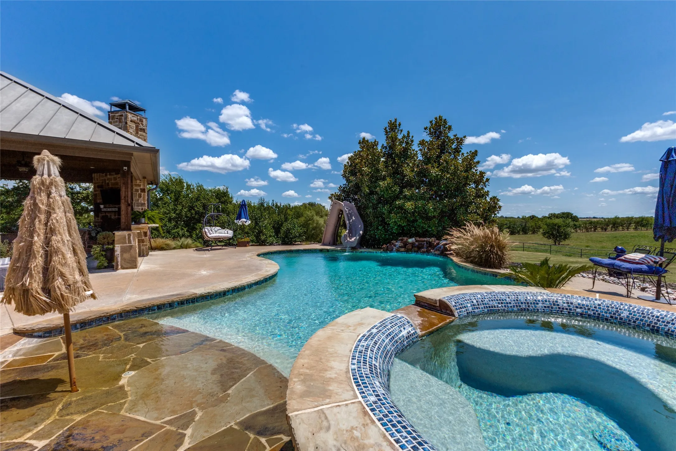 Freeform swimming pool and integrated spa with mosaic tile detailing