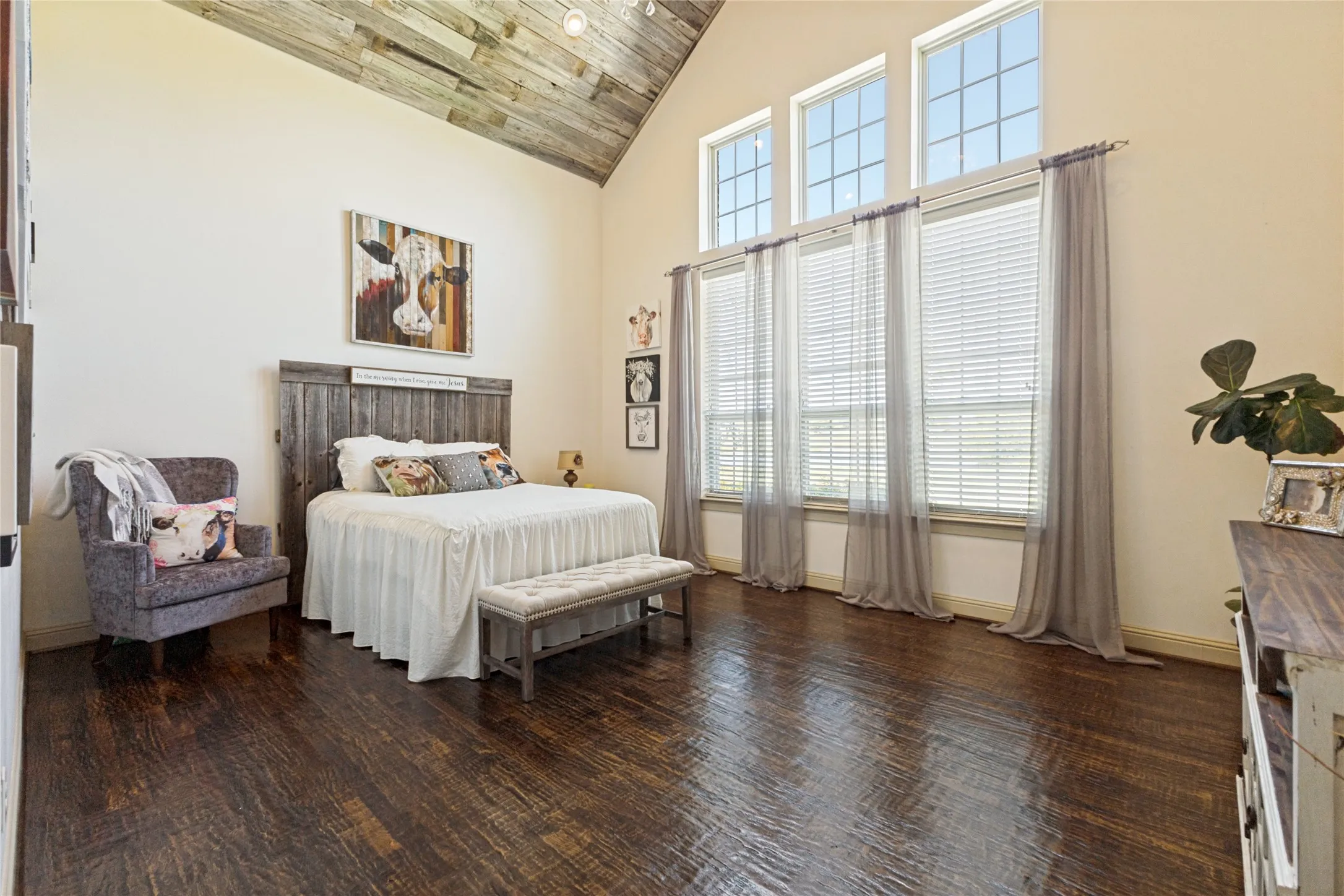 Vaulted ceiling with wood-finish paneling, distressed wood-finish flooring, and multiple tall windows