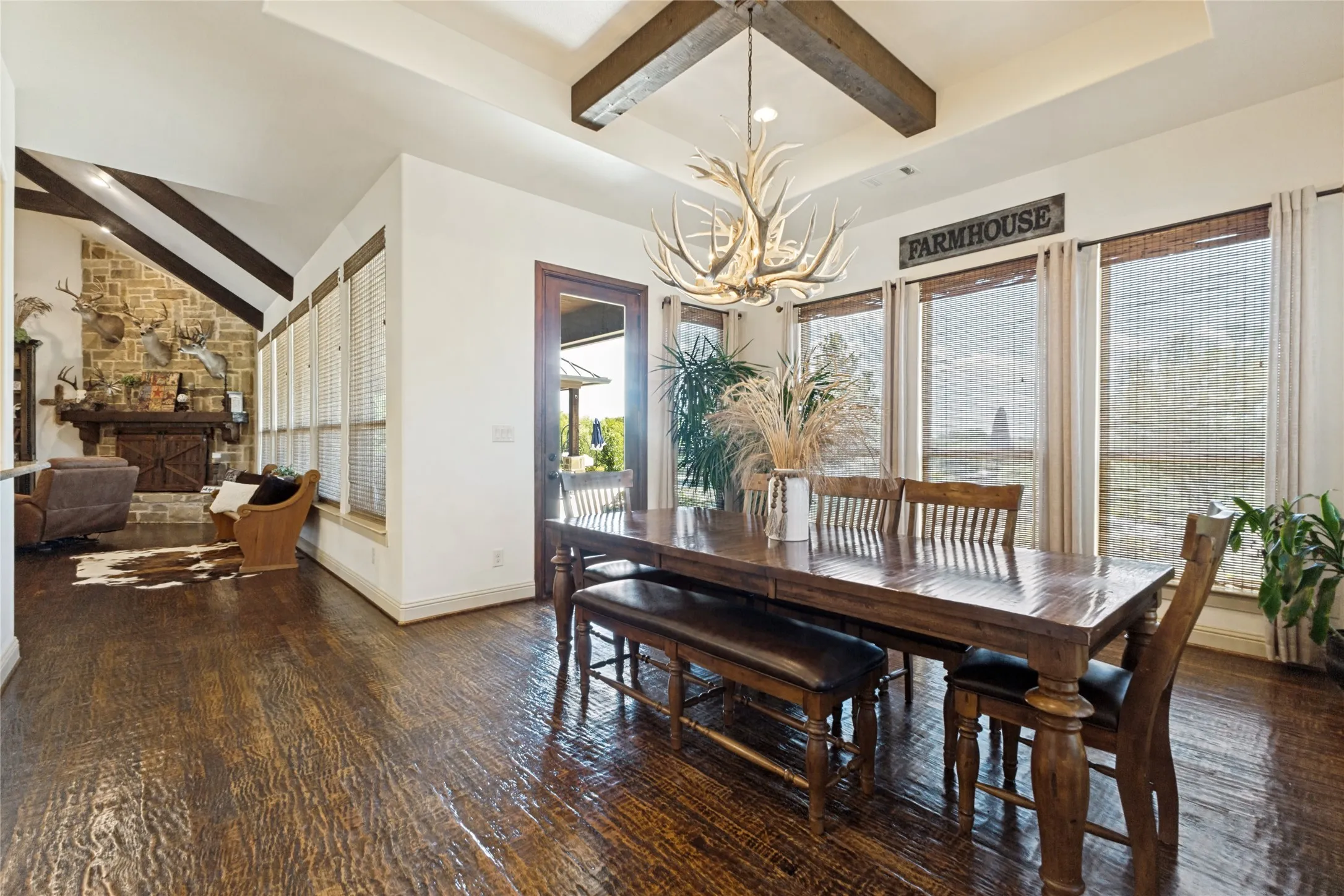 Dark wood-finish flooring throughout, featuring a stone fireplace with a wood mantel
