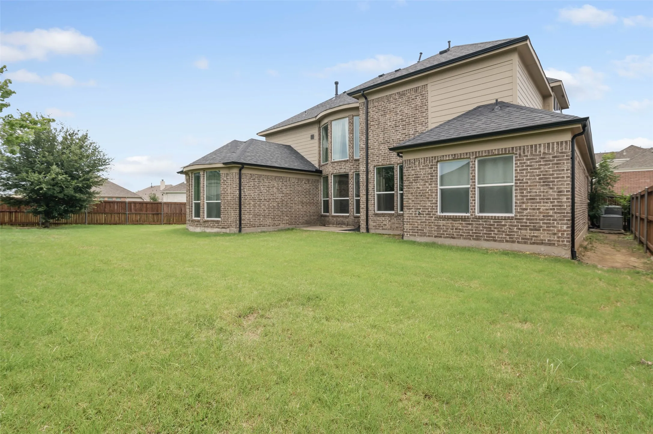 Expansive green lawn with a wood fence perimeter