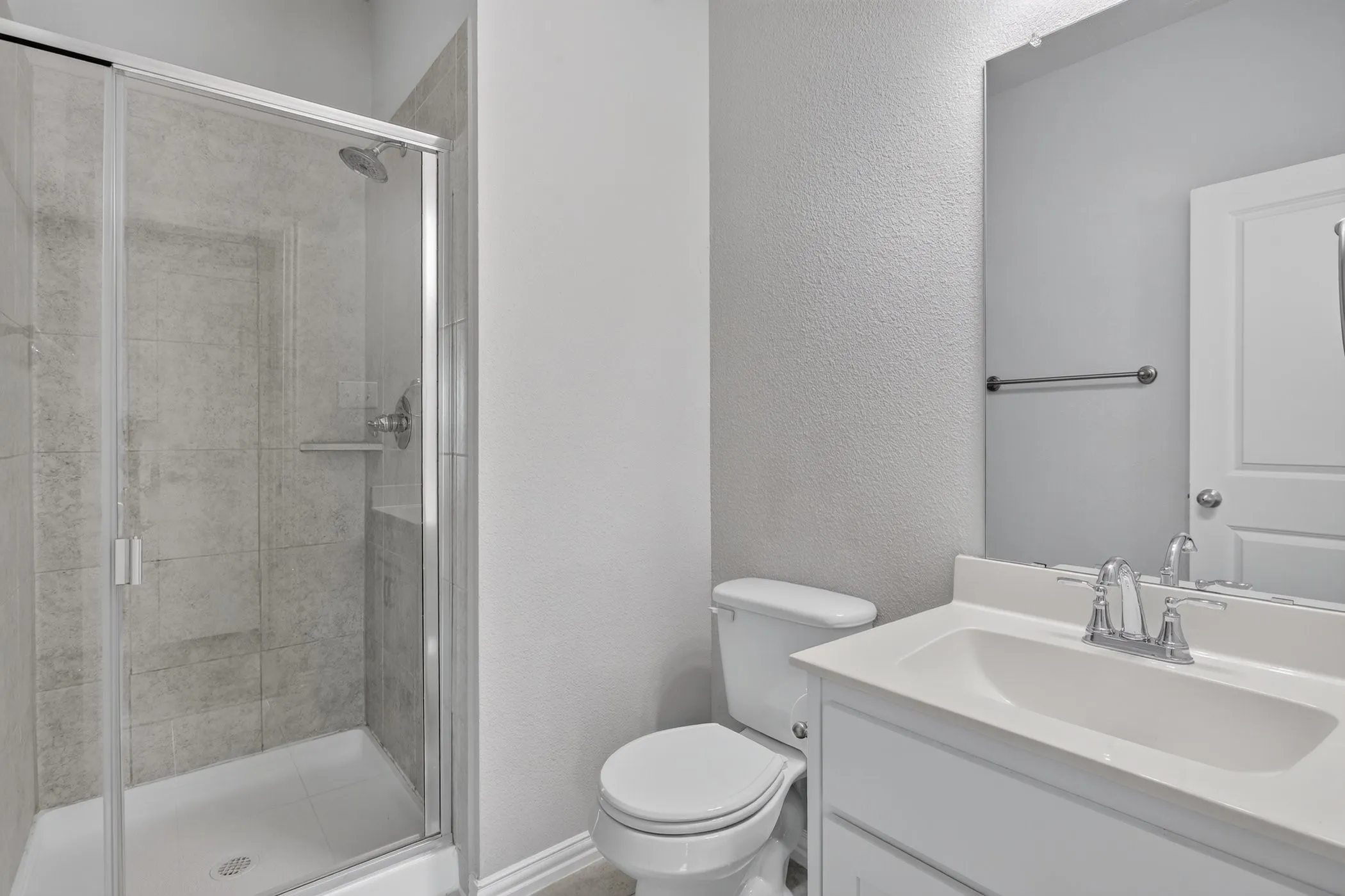 Glass-enclosed shower with tiled walls and built-in shelf