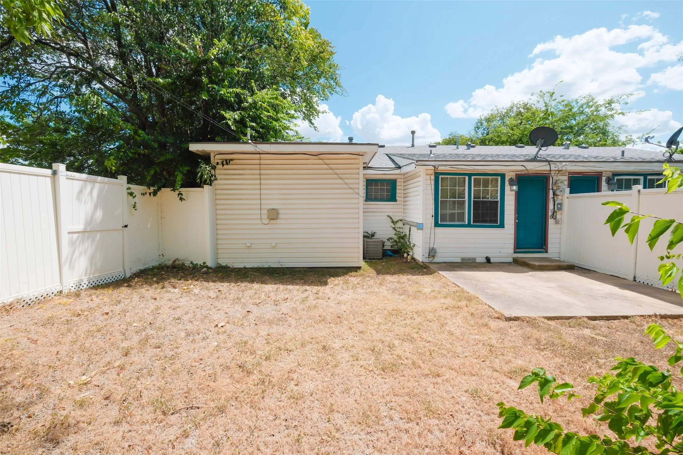 Backyard featuring a concrete patio, full privacy fencing, and exterior entry