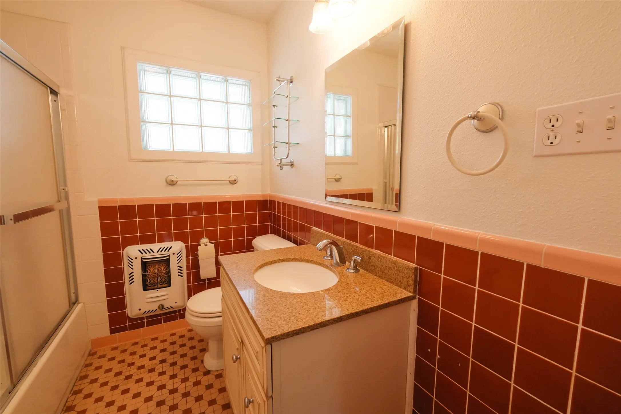Bathroom featuring a vanity with a granite-style countertop, a built-in sink, and a mirrored medicine cabinet