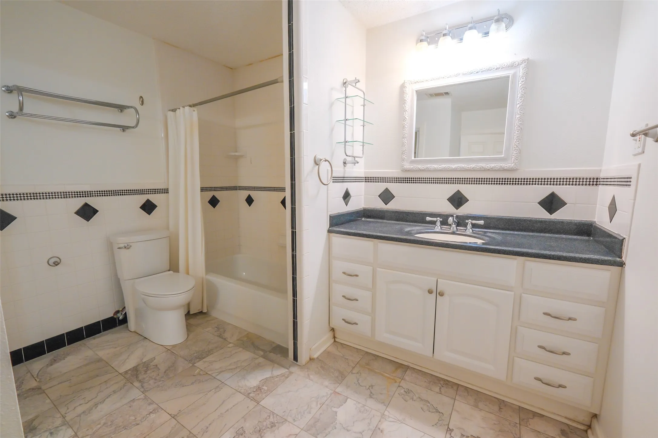 Vanity with an integrated sink, a light fixture, and a framed mirror