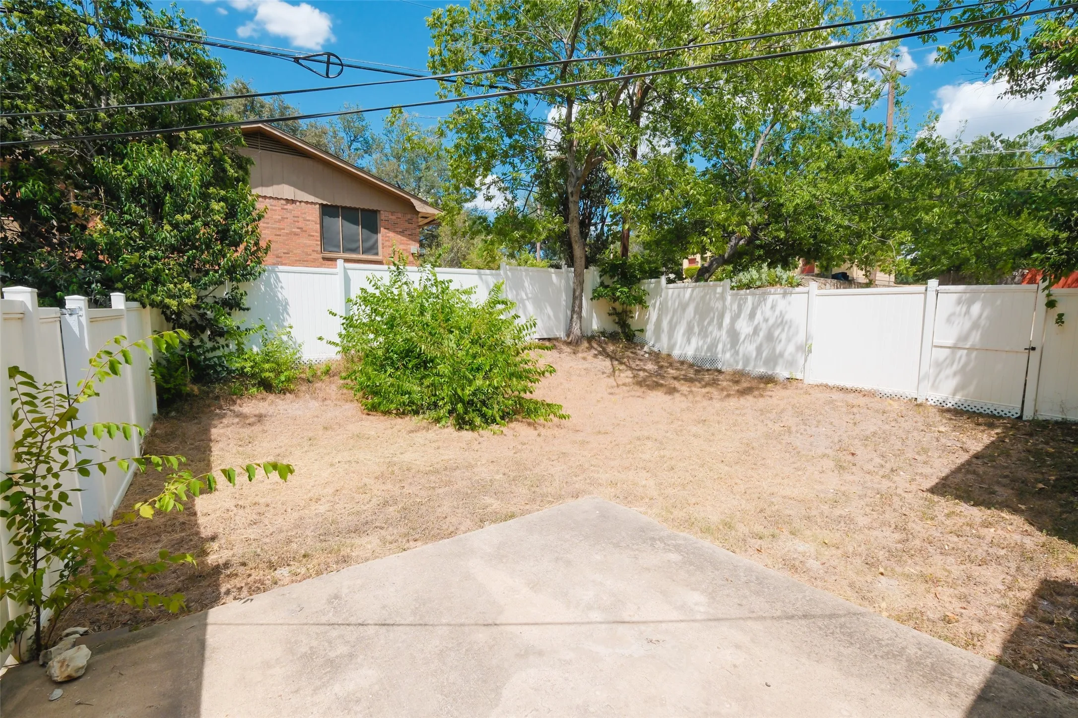 Private backyard with a concrete patio and a perimeter fence