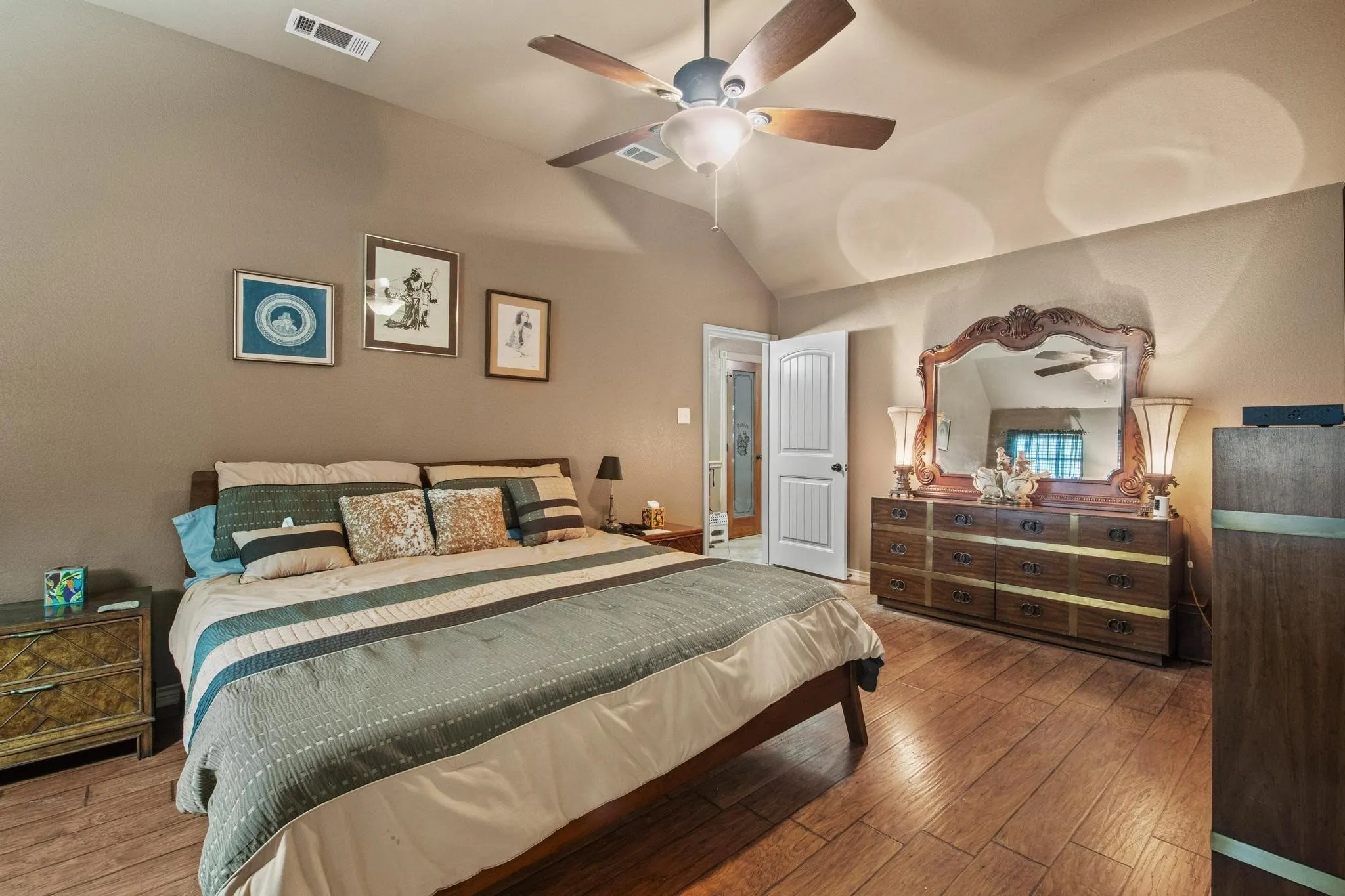 Vaulted ceiling, wood-finish flooring, ceiling fan with integrated lighting, paneled interior door, recessed lighting
