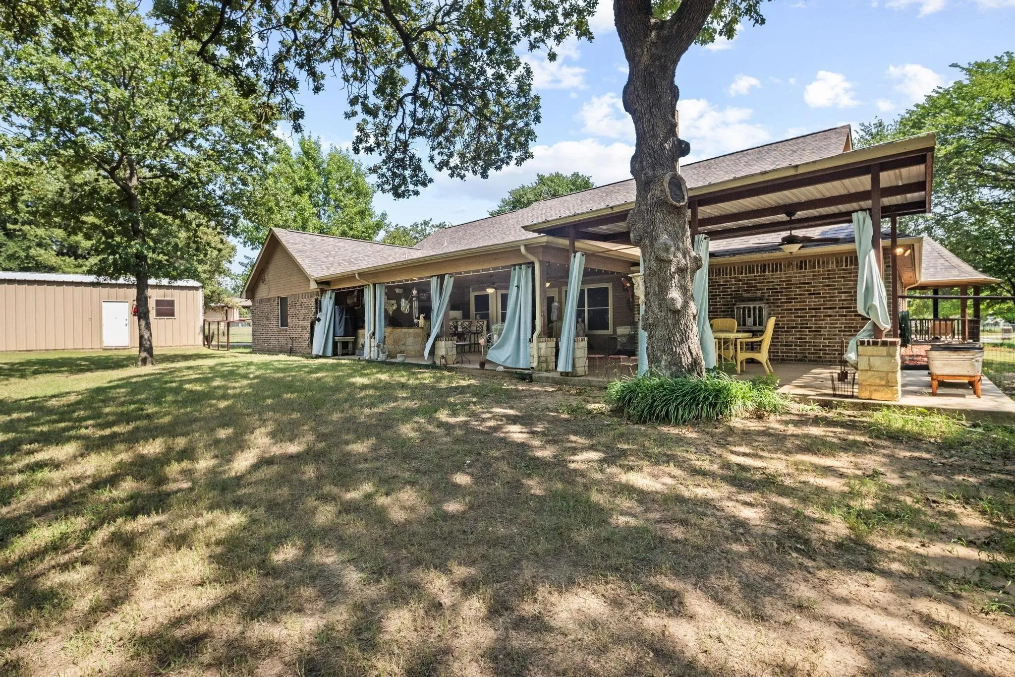 Expansive lawn with mature trees and a detached structure