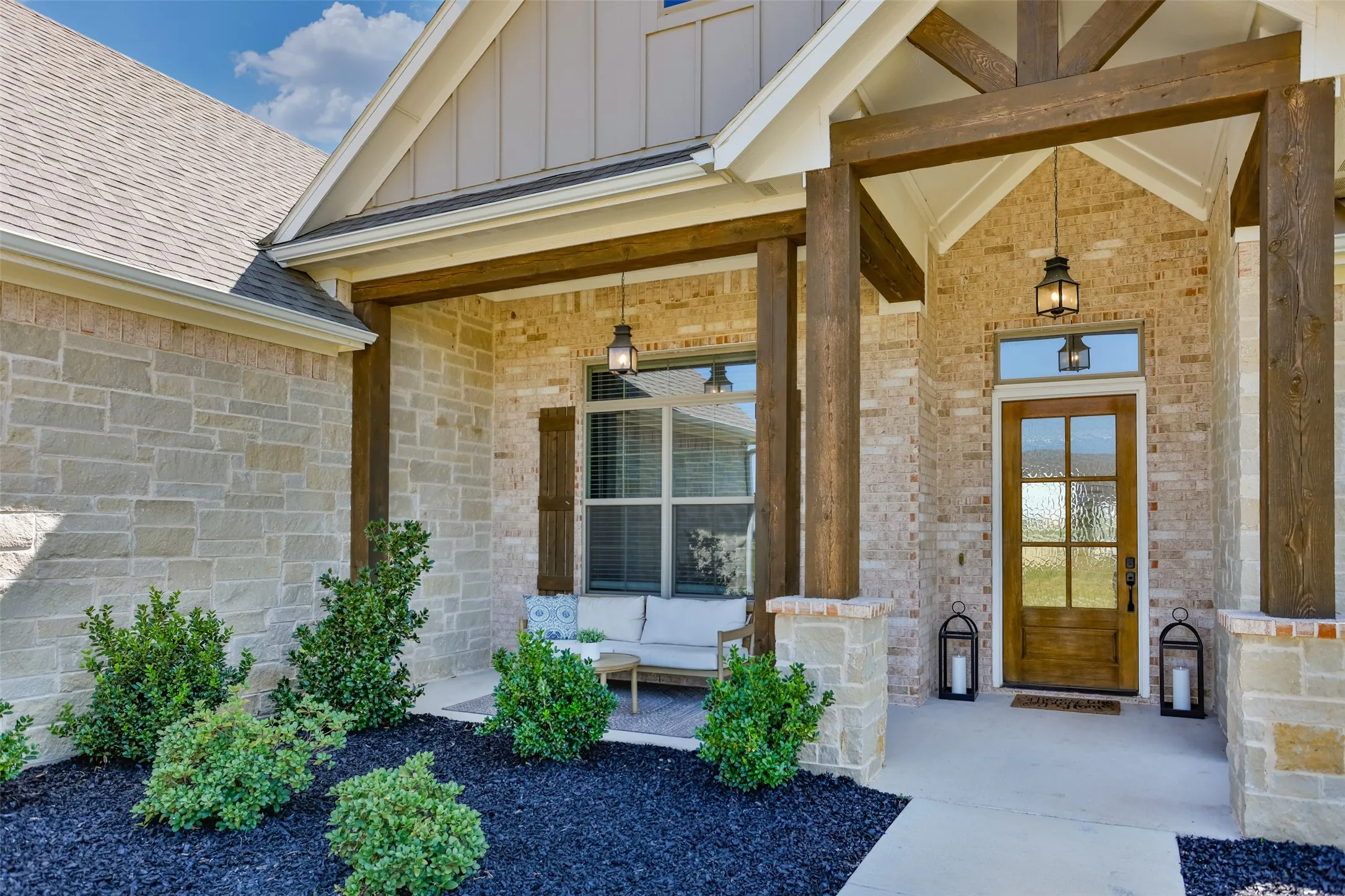 Covered front porch with stone and brick facade