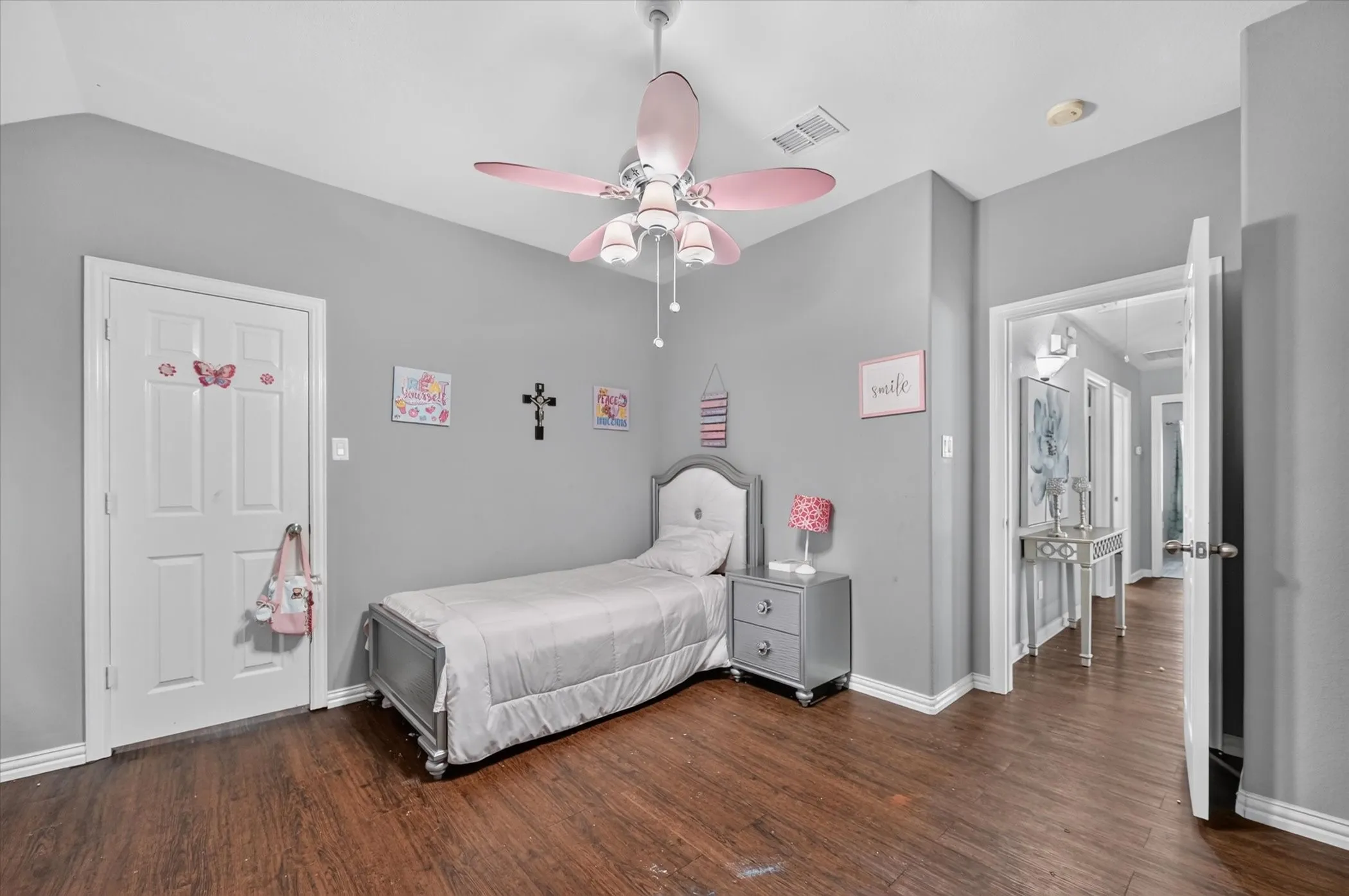 Wood-finish flooring, light gray wall tones, and a ceiling fan with light fixture