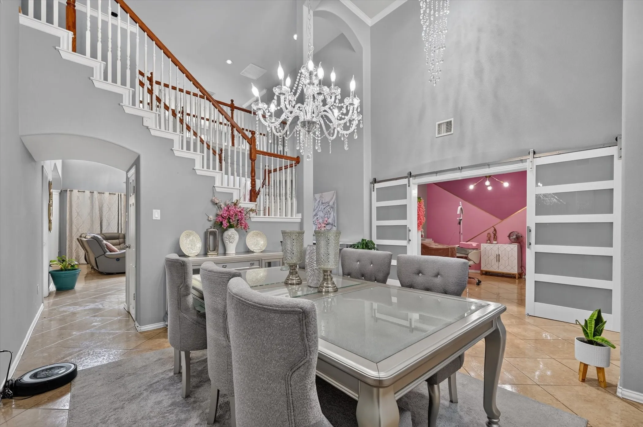 Two-story entryway with a grand staircase featuring wood handrails and white balusters