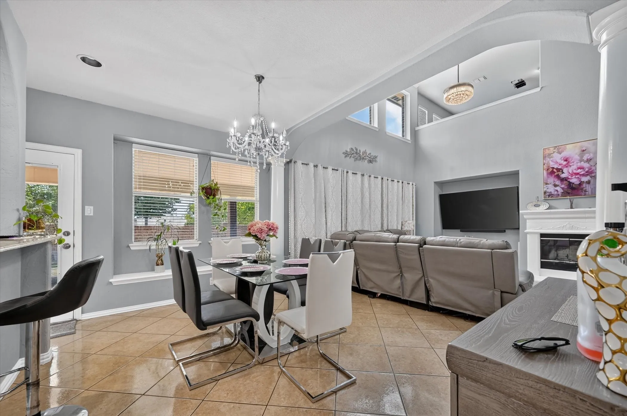 Two-story living area with high ceilings, recessed lighting, and a fireplace with a decorative mantel