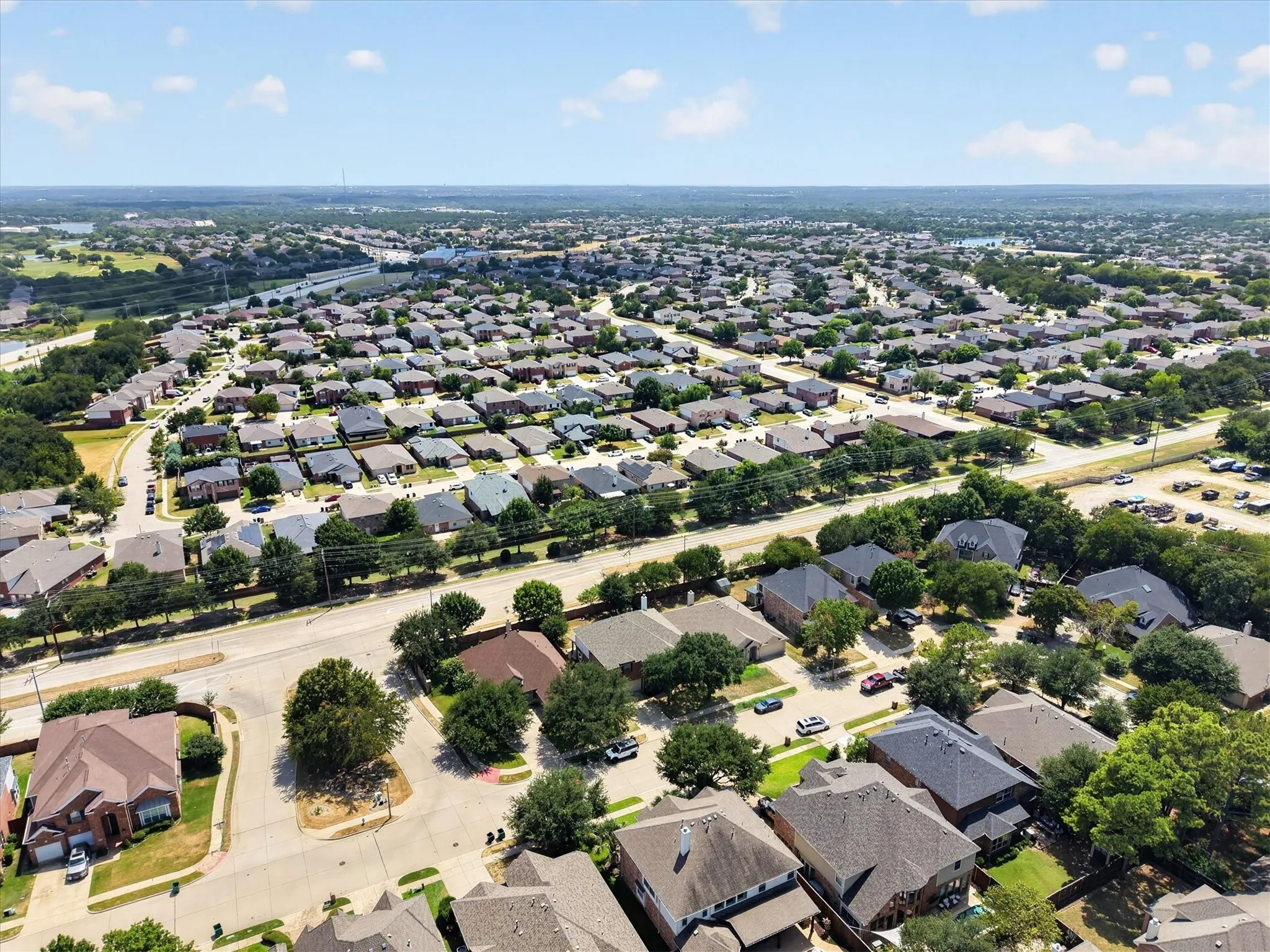 Expansive residential community with mature trees, visible waterways, and a clear sky