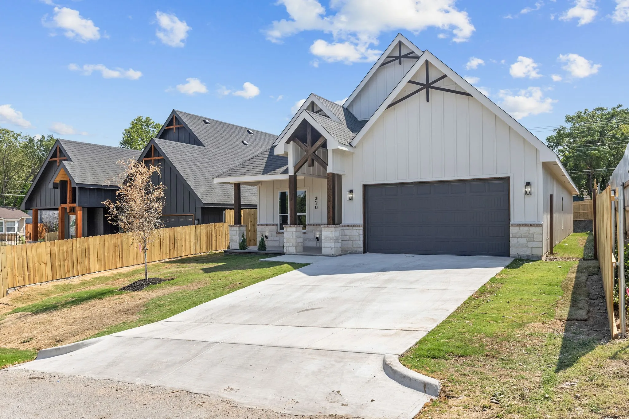 Modern farmhouse exterior featuring board and batten siding, stone accents, and an attached garage