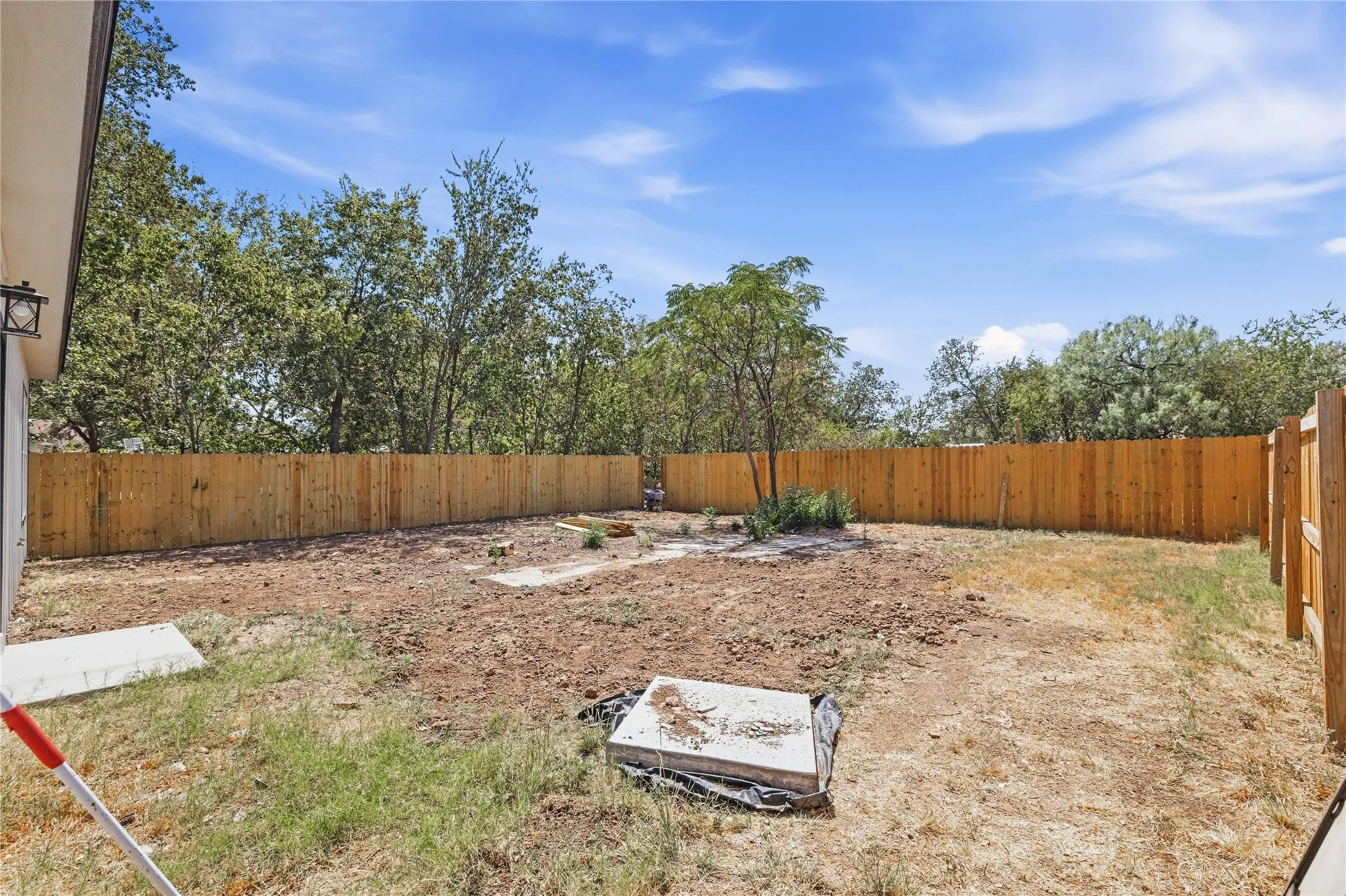 Expansive backyard with a new wood privacy fence and mature perimeter trees