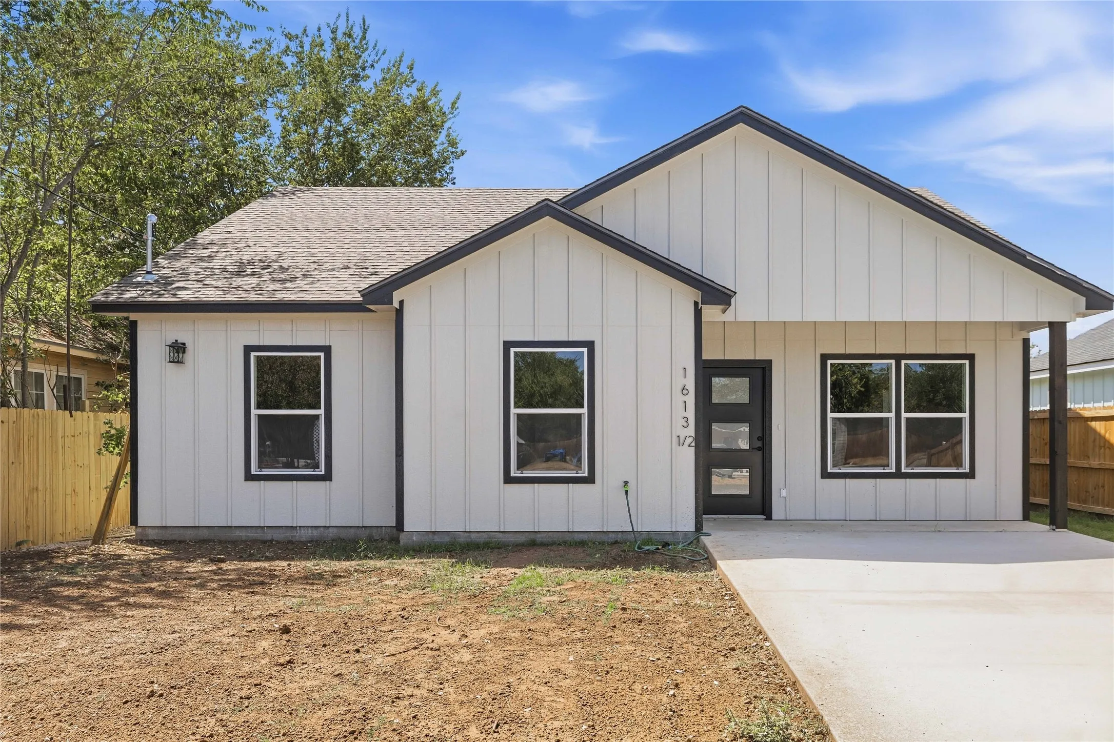 Contemporary exterior with vertical panel siding, dark trim accents, and a modern front entry door