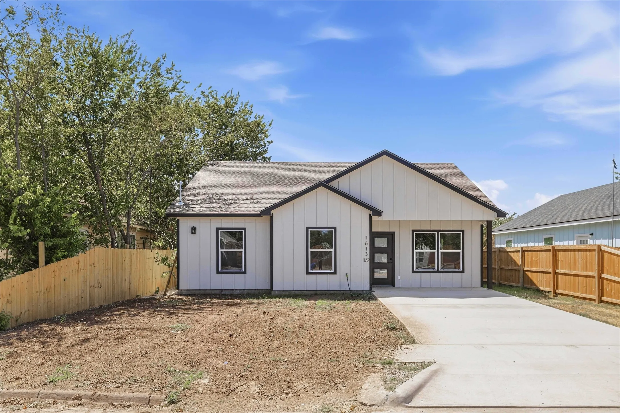 Contemporary exterior with vertical panel siding, dark trim windows, and a concrete driveway