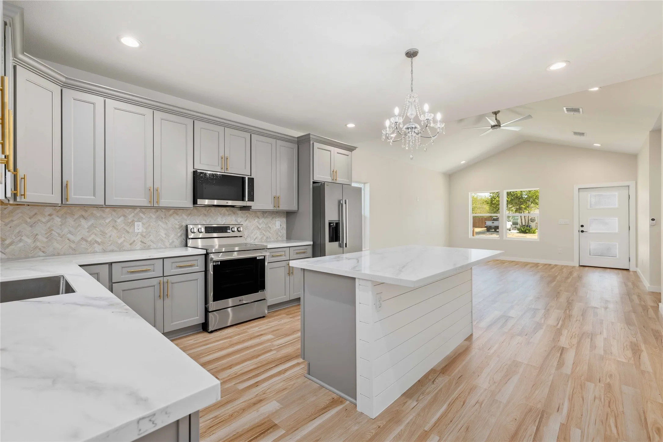 Kitchen with white countertops, light gray cabinetry, stainless steel appliances