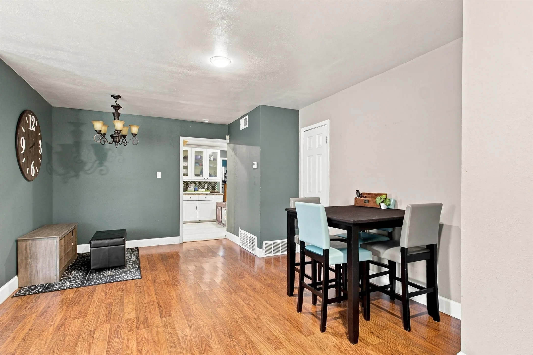 Wood-finish flooring throughout, recessed ceiling lighting, and a chandelier fixture