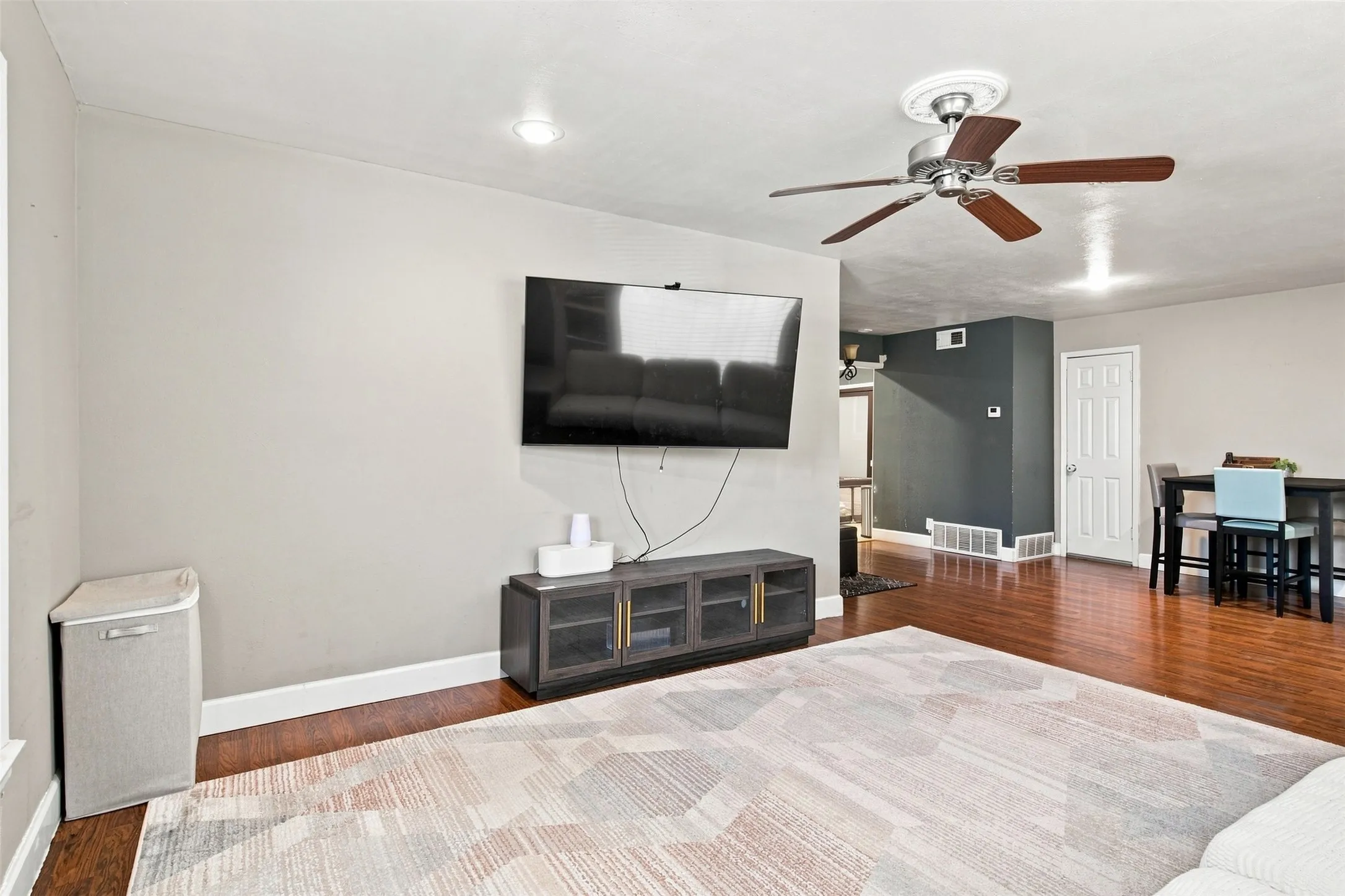 Recessed ceiling lighting, wood-finish flooring, and a ceiling fan with integrated lighting