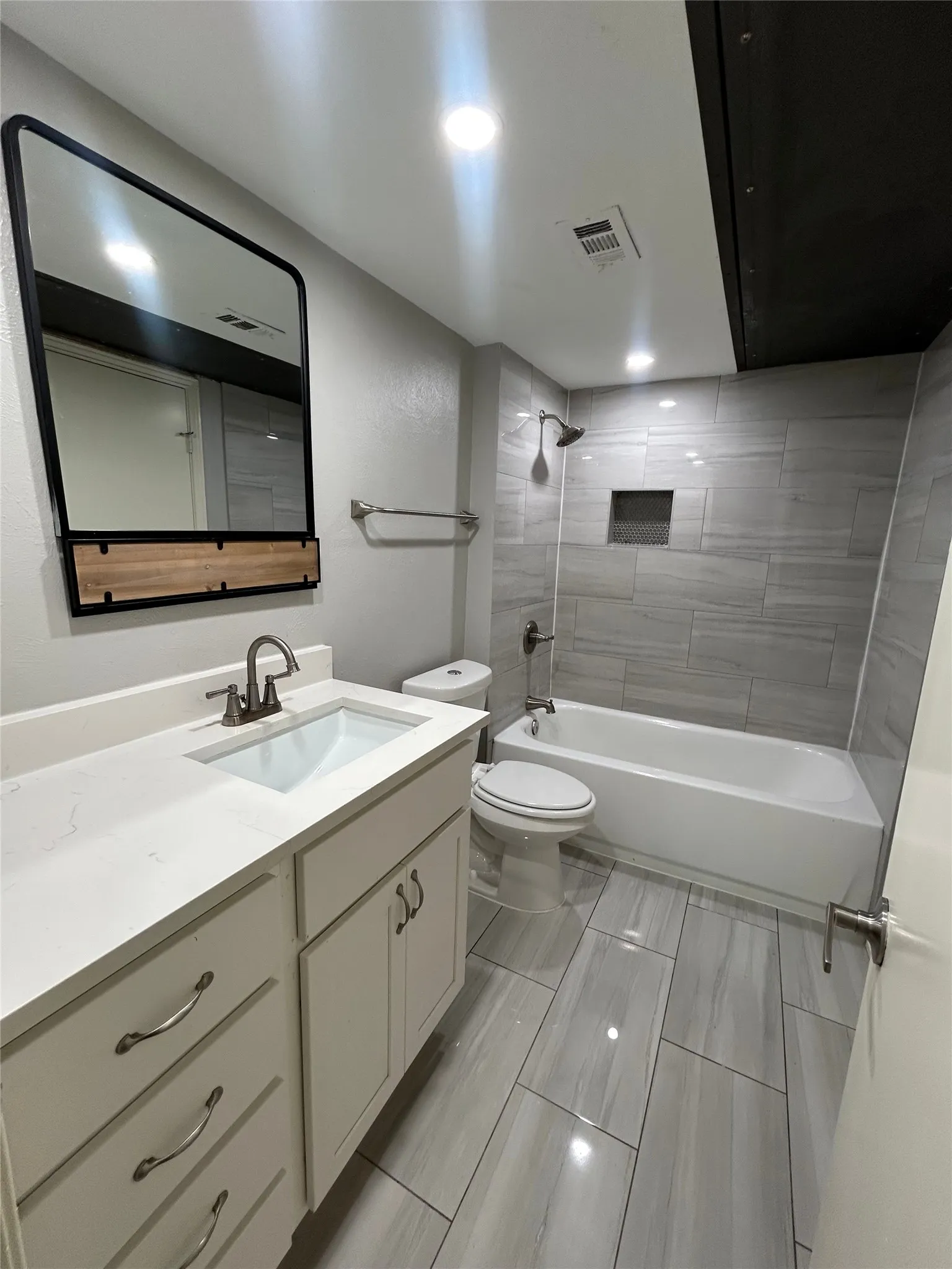Bathroom featuring a vanity with an integrated sink, a white countertop, and white cabinetry