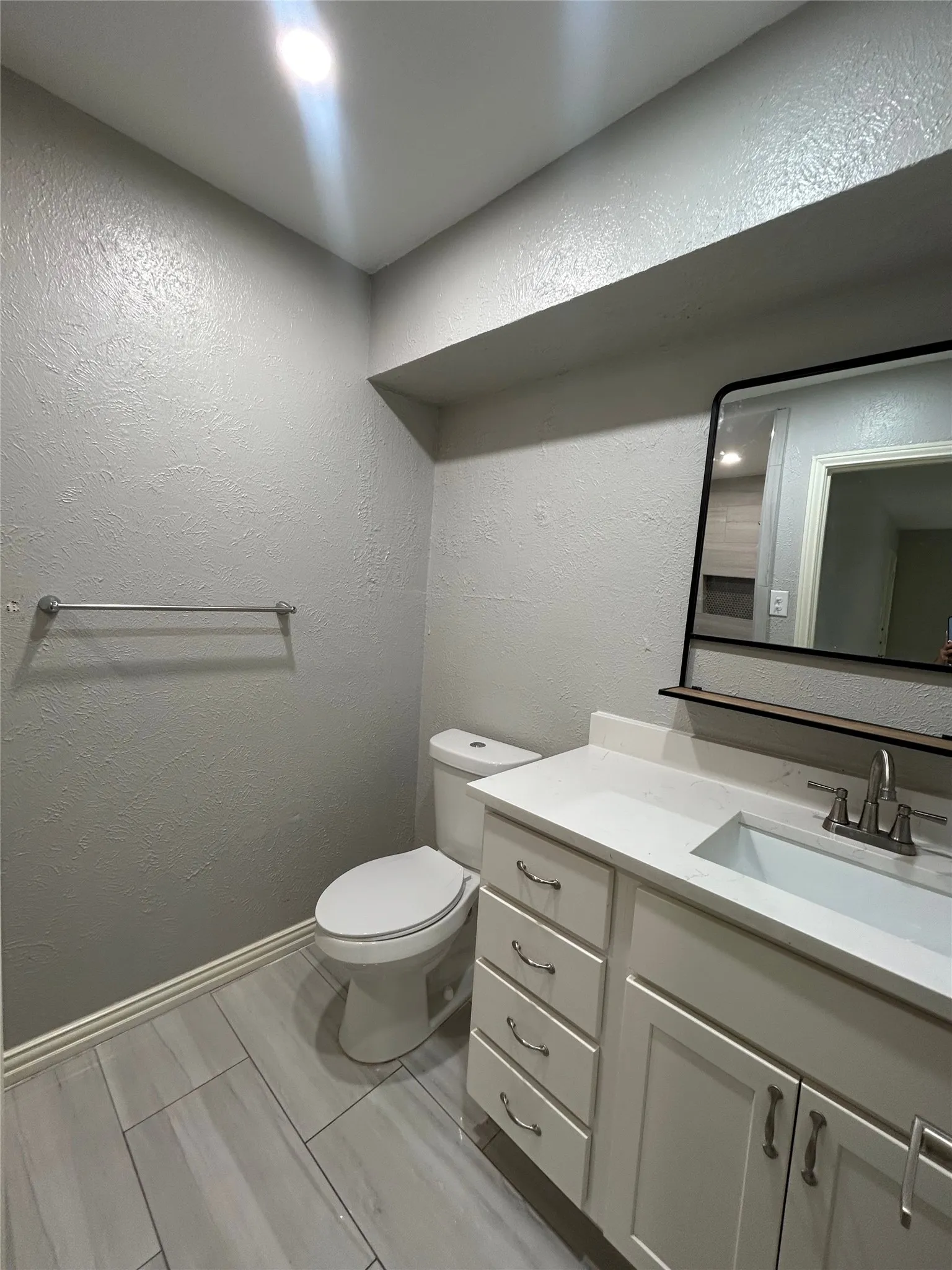 White vanity with shaker-style cabinetry, a white countertop, and an undermount sink