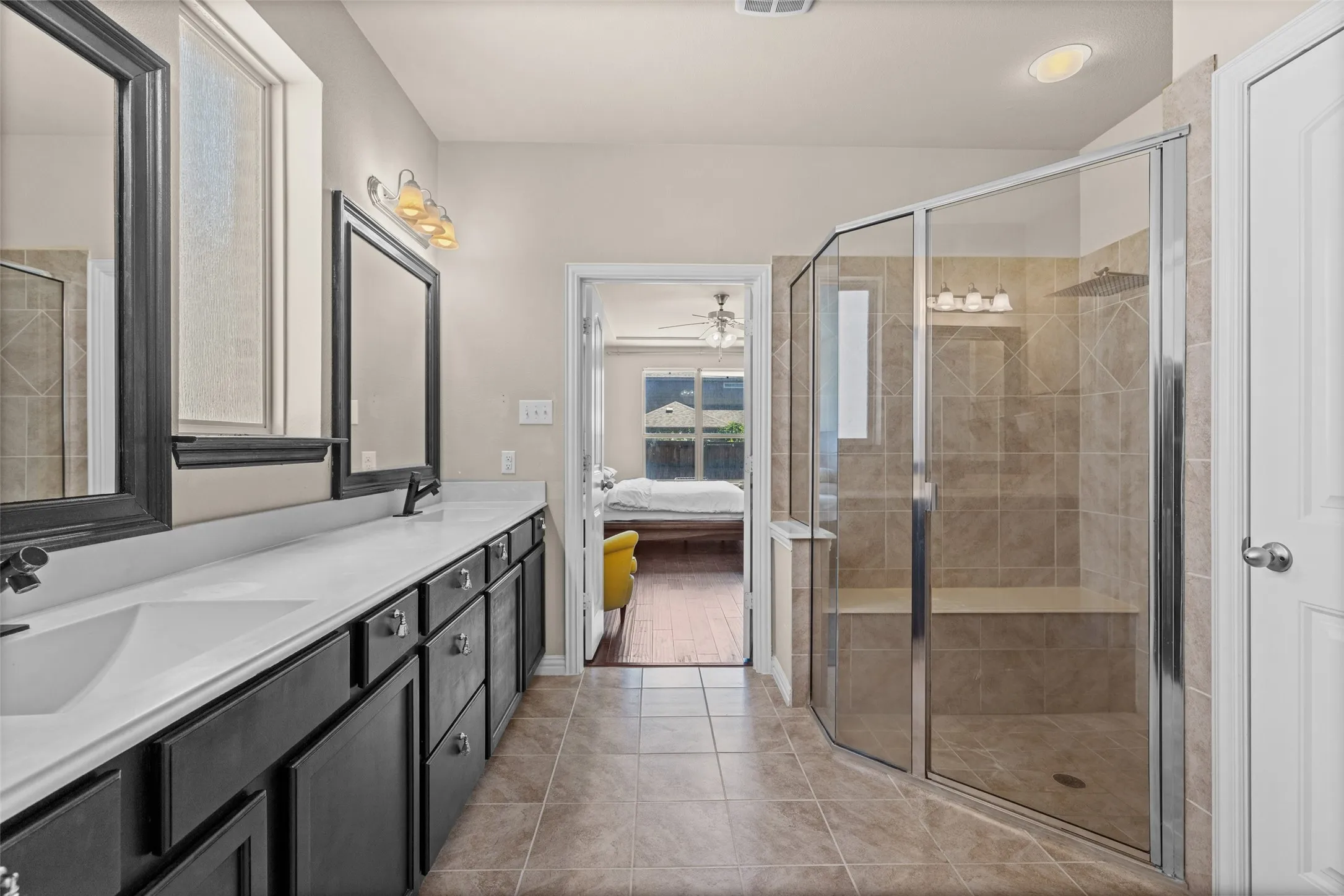 Dual vanity with integrated sinks, dark wood-finish cabinetry, and framed mirrors
