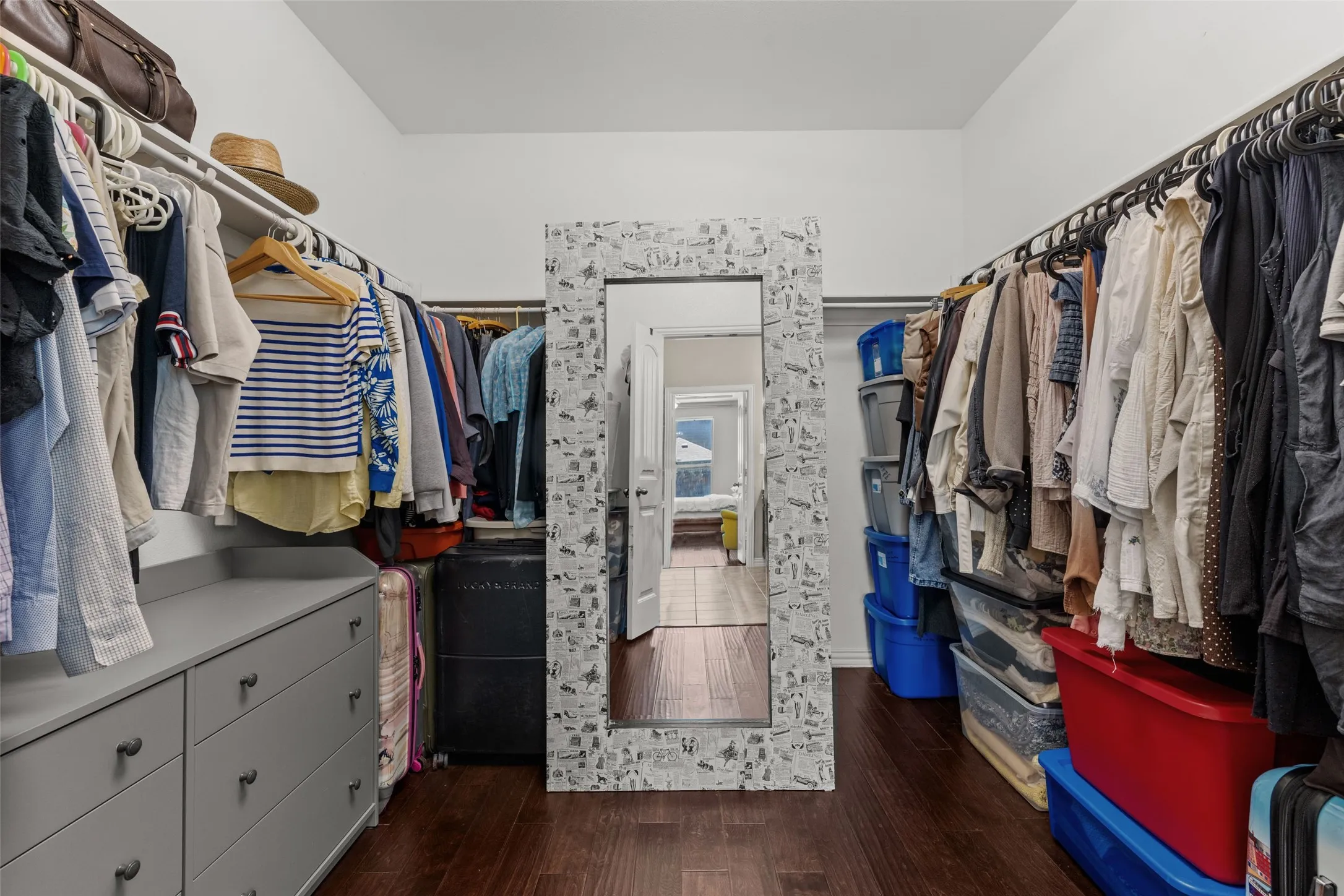 Wood-finish flooring, built-in storage with hanging rods, built-in drawer storage, and recessed lighting