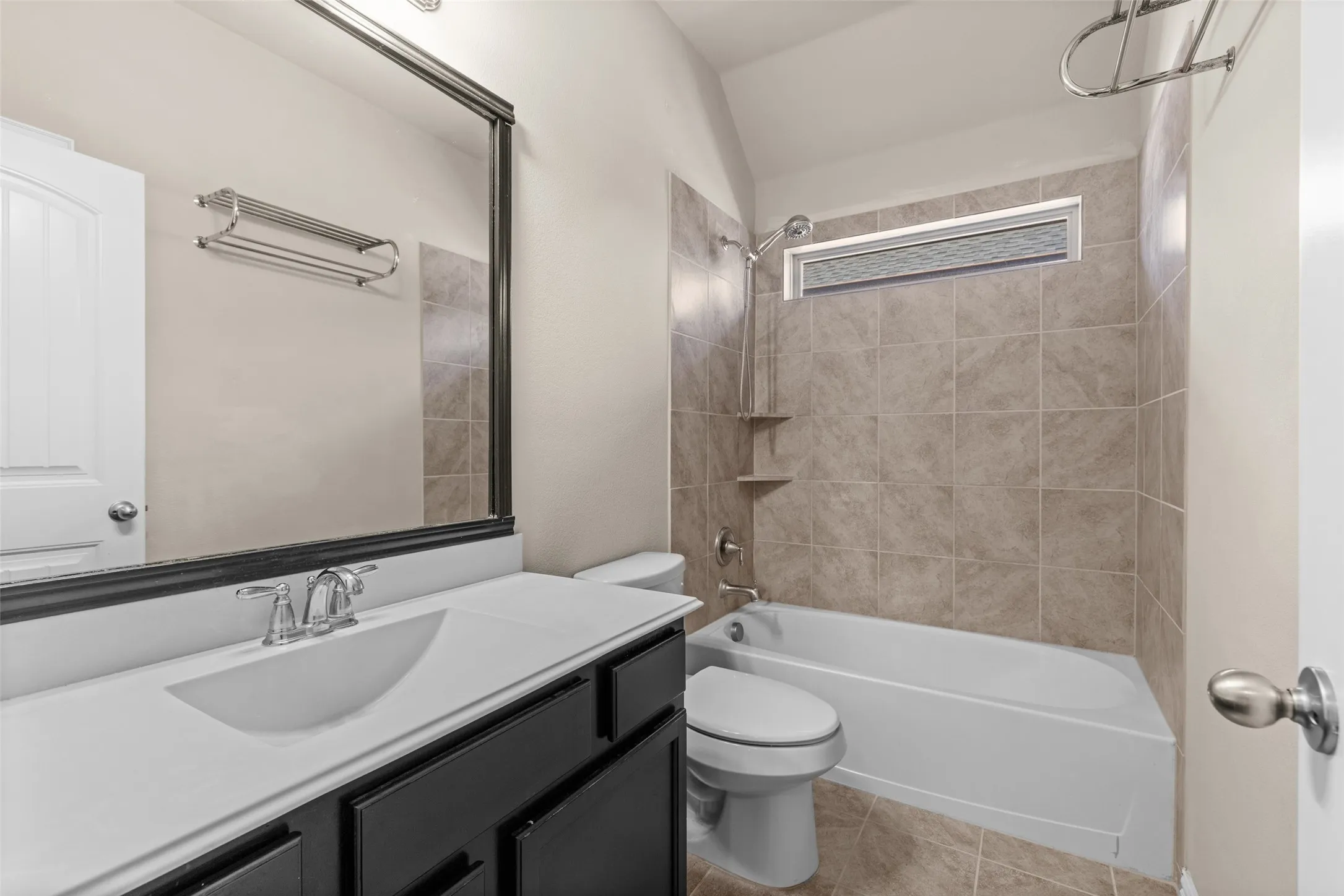 Bathroom featuring a single vanity with dark cabinetry, white countertop, and integrated sink