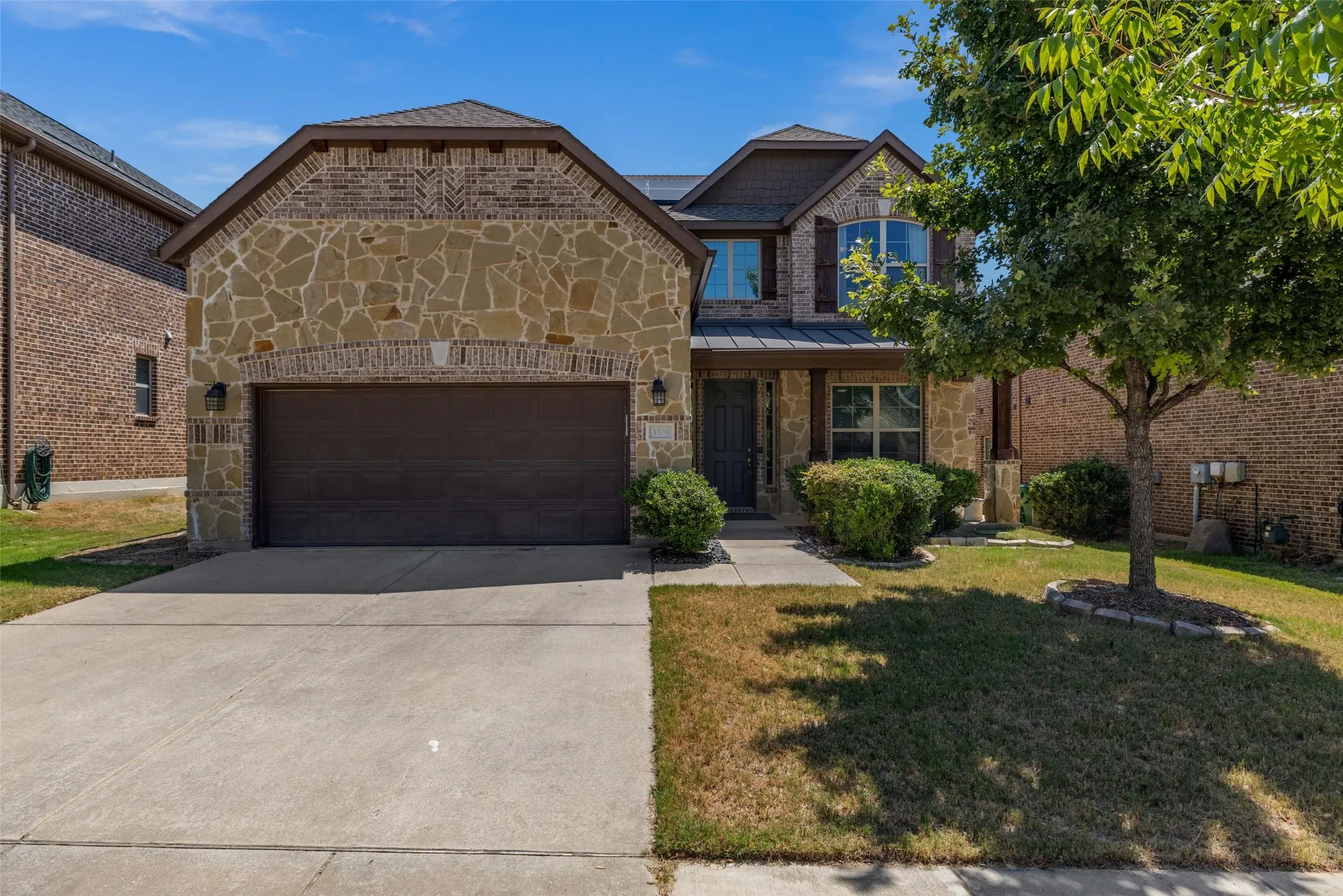 Stone and brick exterior with a two-car garage