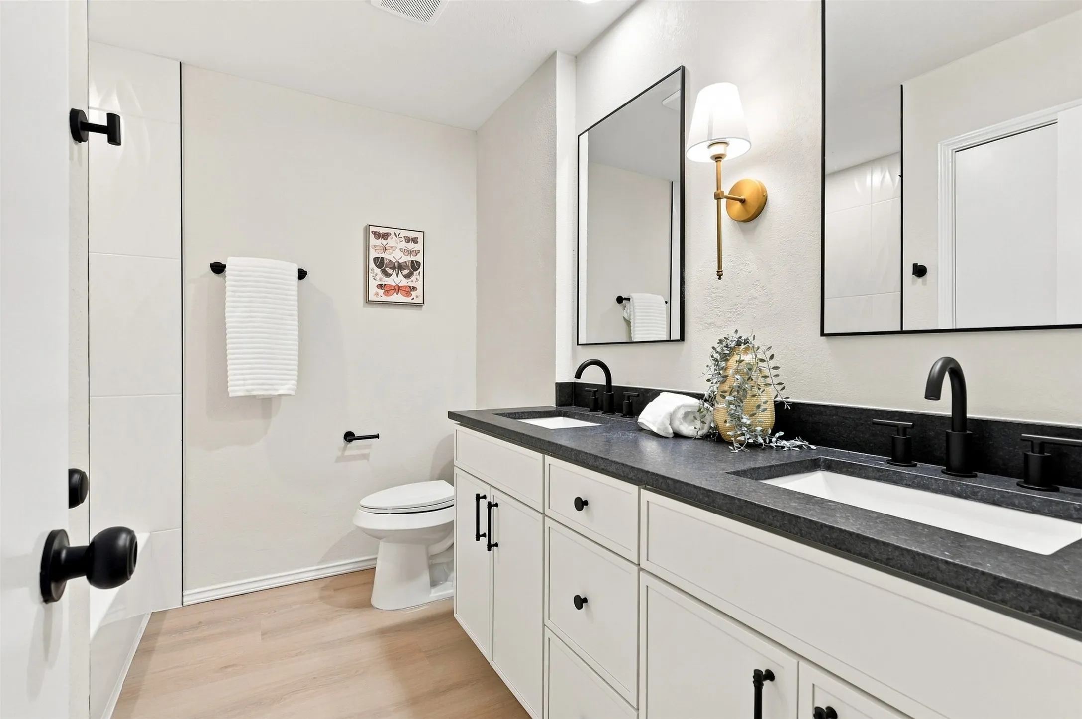 Dual vanity with undermount sinks, matte black fixtures, and dark stone-finish countertop