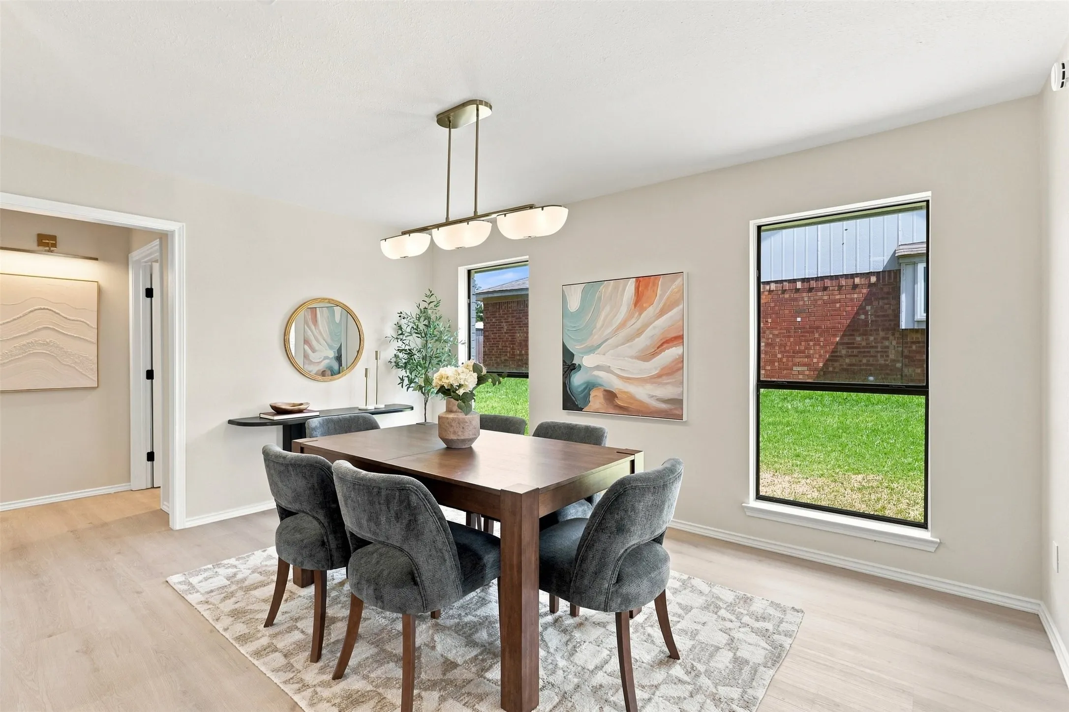 Light wood-finish flooring with a rectangular area rug