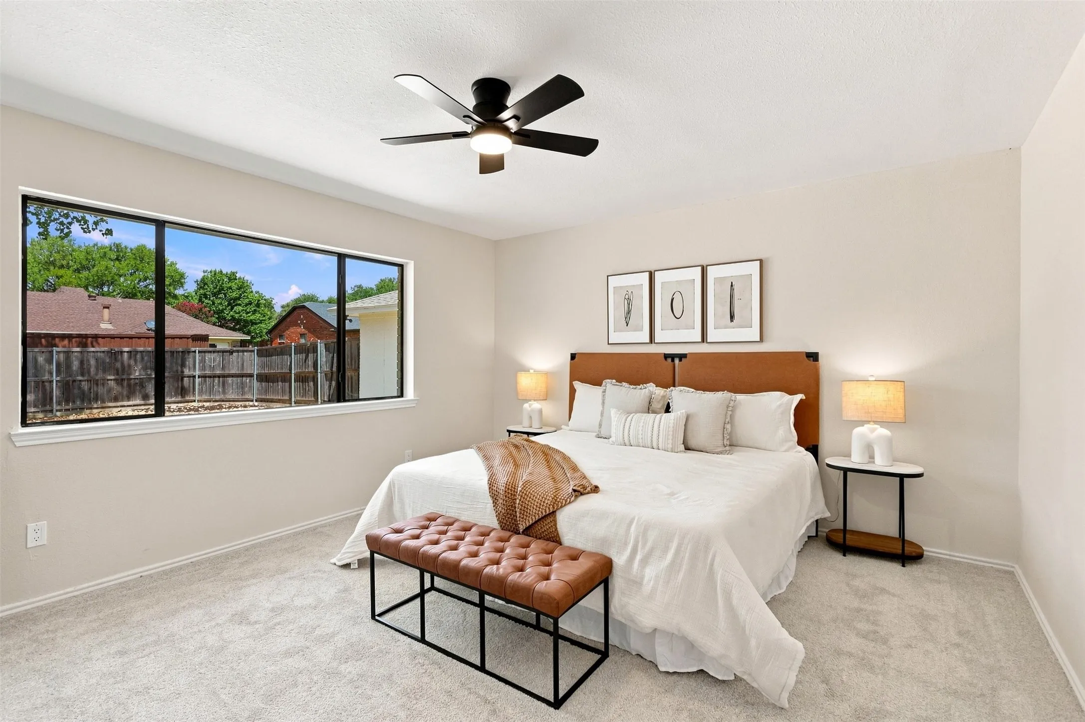 Light-colored carpeted flooring, a wide window with dark framing, and a ceiling fan with black​​‌​​​​‌​​‌‌​‌‌​​​‌‌​‌​‌​‌​​​‌​​ blades