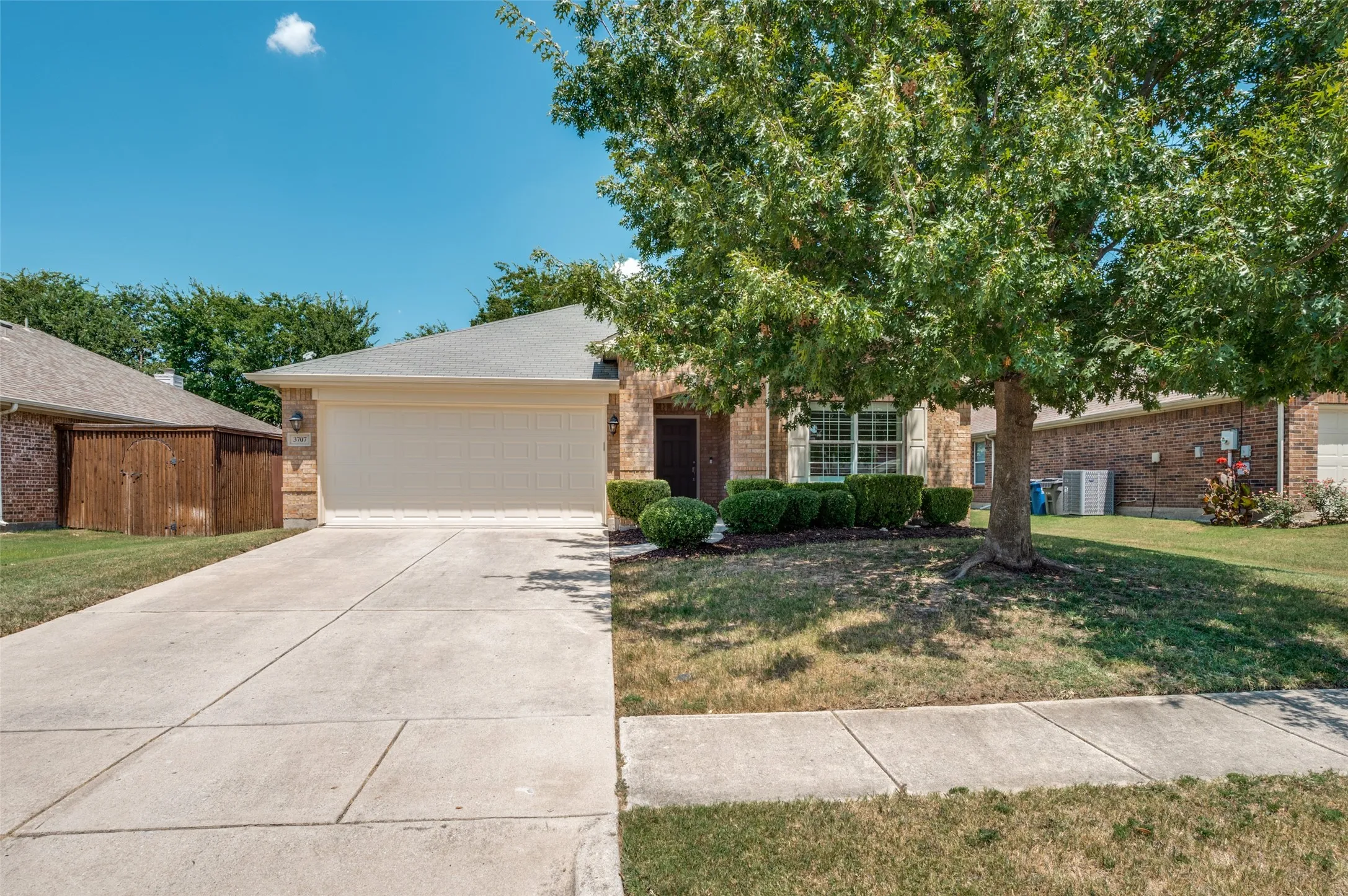 Concrete driveway and brick exterior with a two-car garage