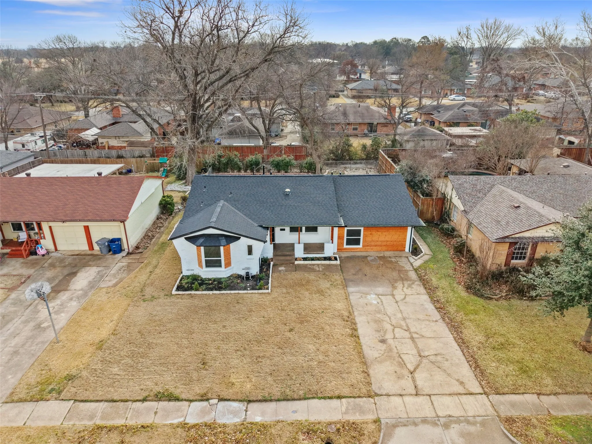 The property features a dark-colored roof, a light-colored exterior, and an attached driveway